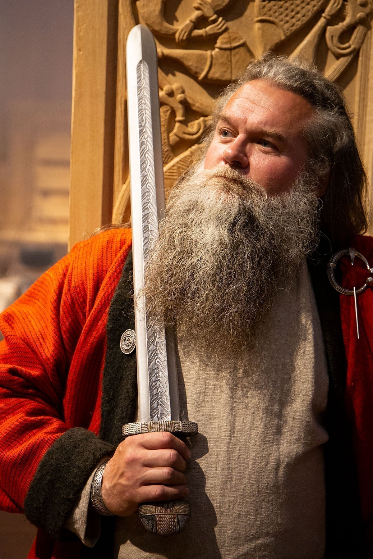 A historical reenactor holds The EirikR Sword, showcasing its intricate design and craftsmanship.