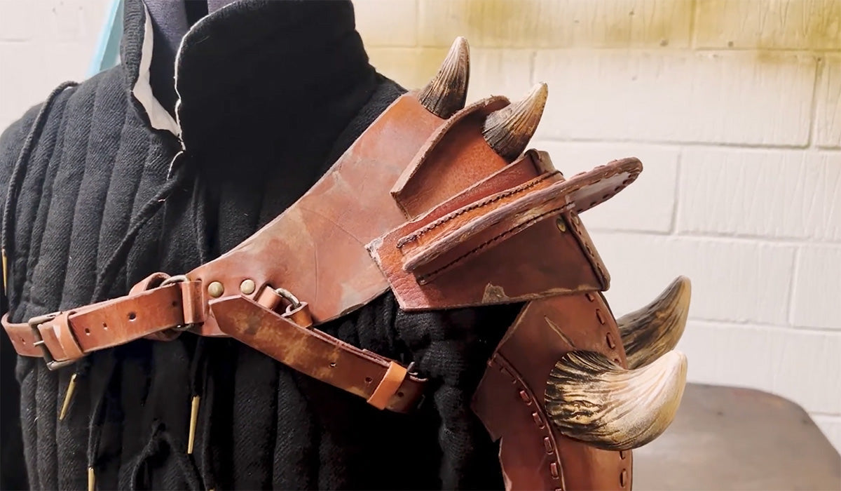 Detailed view of a leather shoulder harness with horns, featured in the article "Tweaks and Tales."