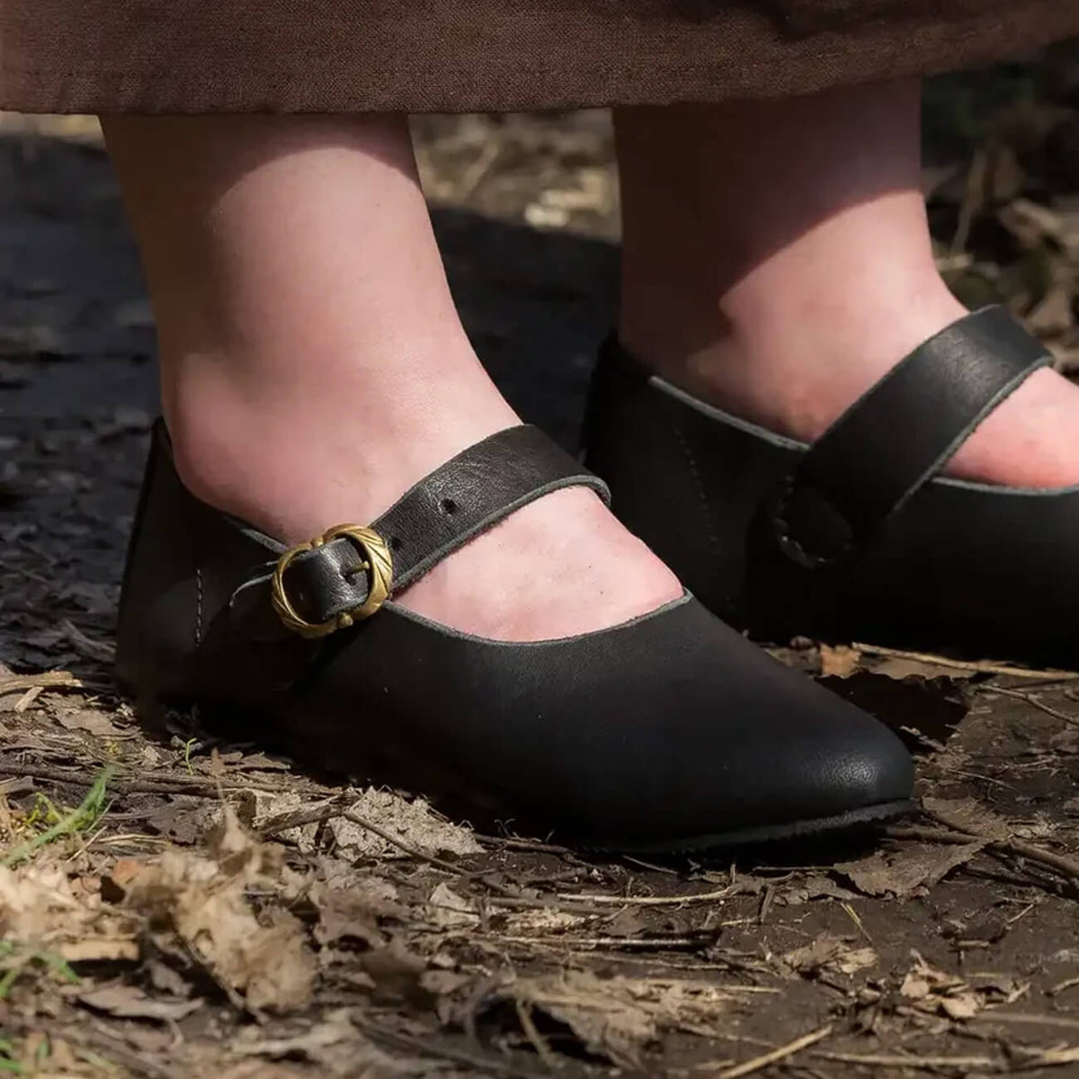 Renaissance and Medieval Footwear featuring black leather shoes with a buckle strap and pointed toes.