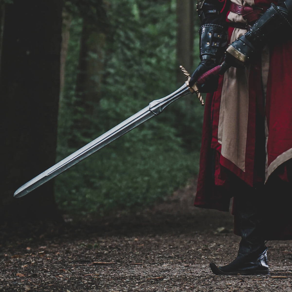 Long Swords: A knight holding a long sword in a forest, showcasing its straight, double-edged design.