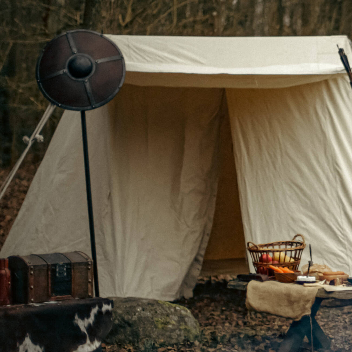 Medieval Tents showcased in a forest setting with a shield, food, and rustic furniture.