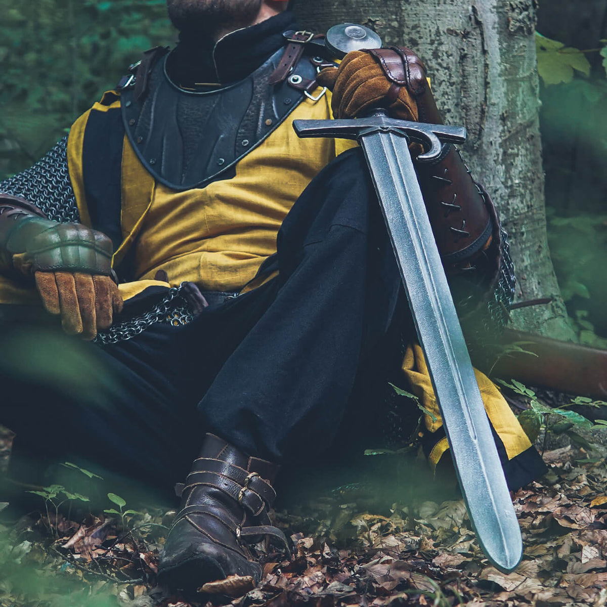 A well-equipped adventurer rests with a medium sword, showcasing the classic choice for LARP combat.