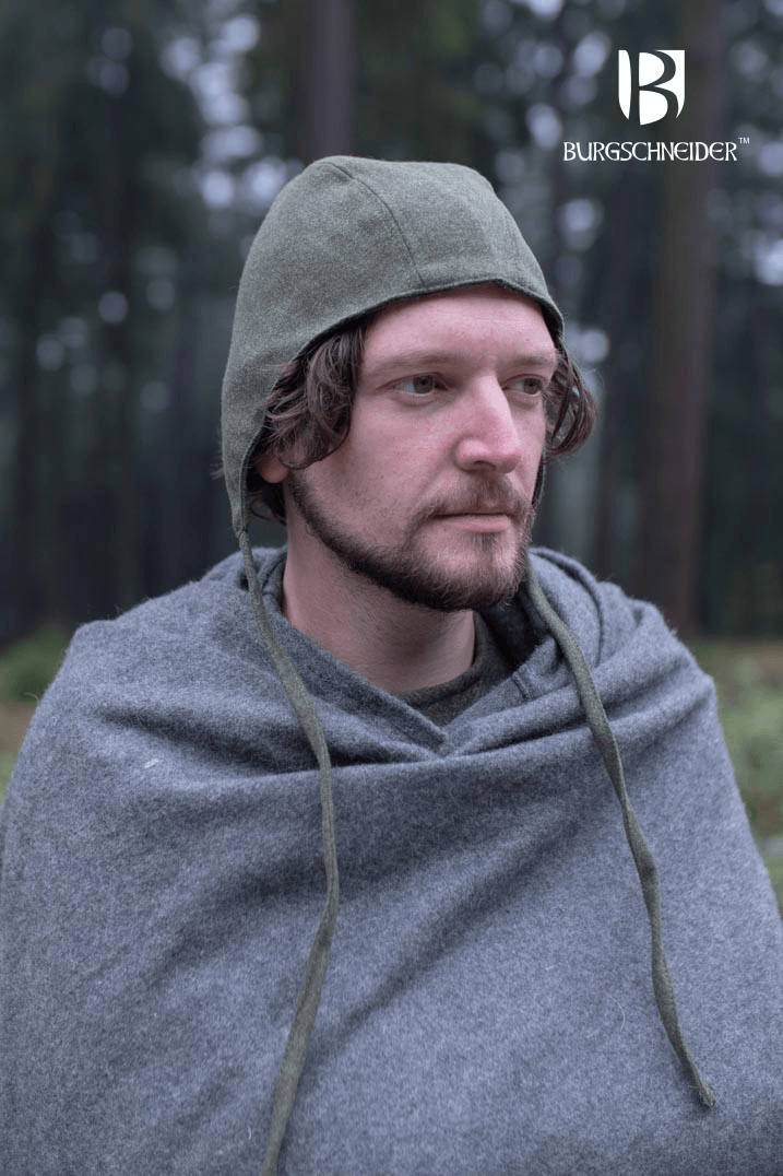 Man wearing the Bundling Hood Wolfram by Burgschneider in a forest setting, showcasing its medieval style and warmth.