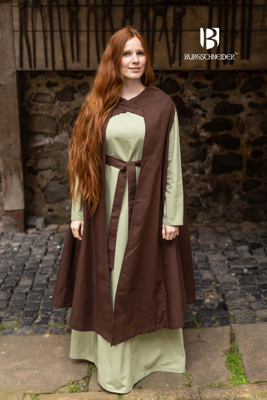 Model wearing Cape Morpheus by Burgschneider in natural setting, showcasing elegant design and striking straps.