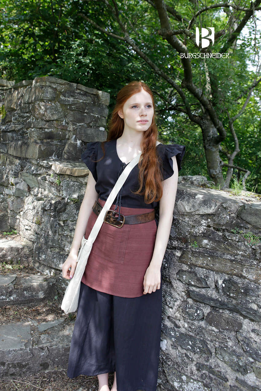 Model wearing the Bag Ehwaz, a medieval-style bag by Burgschneider, styled with historical clothing.