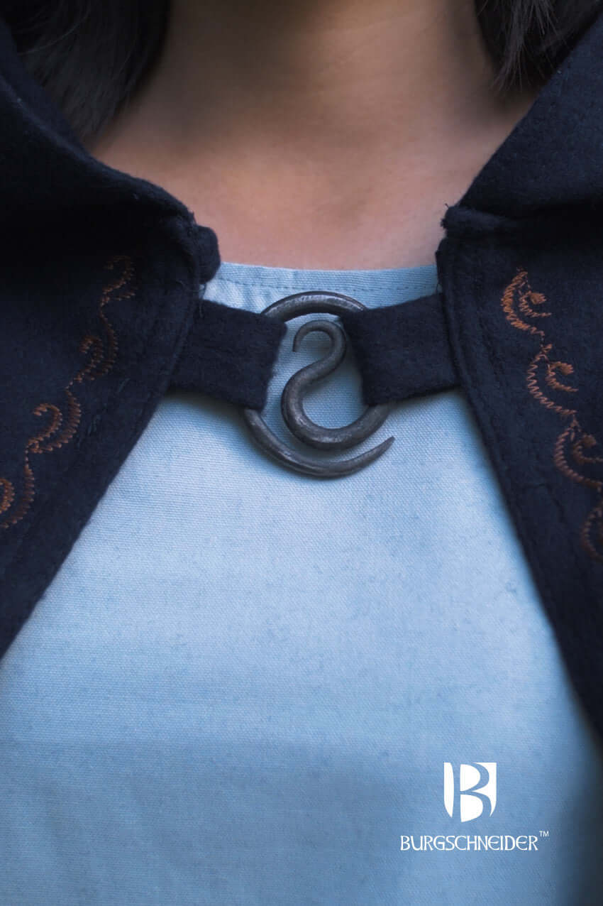 Brooch Spiral Brooch Lukka fastening a black cloak with elegant spiral design.