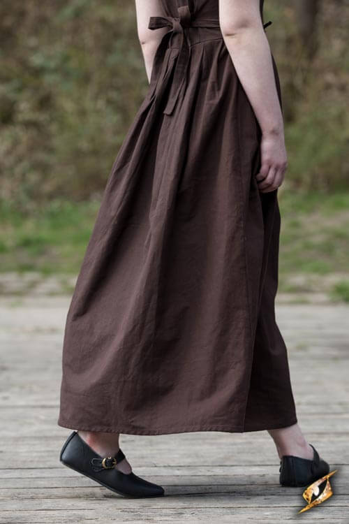 A woman wearing a long brown dress and Shoes Astrid, showcasing the shoes' classic style and comfort.