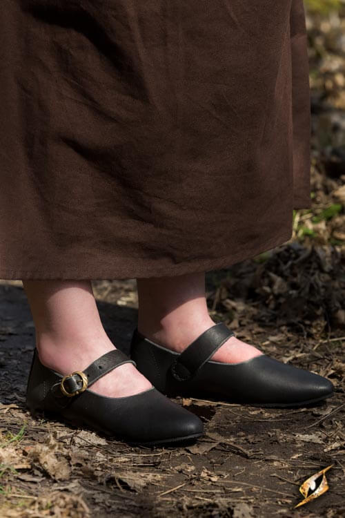 Shoes Astrid worn with a brown skirt on a natural path, showcasing their stylish yet comfortable design.
