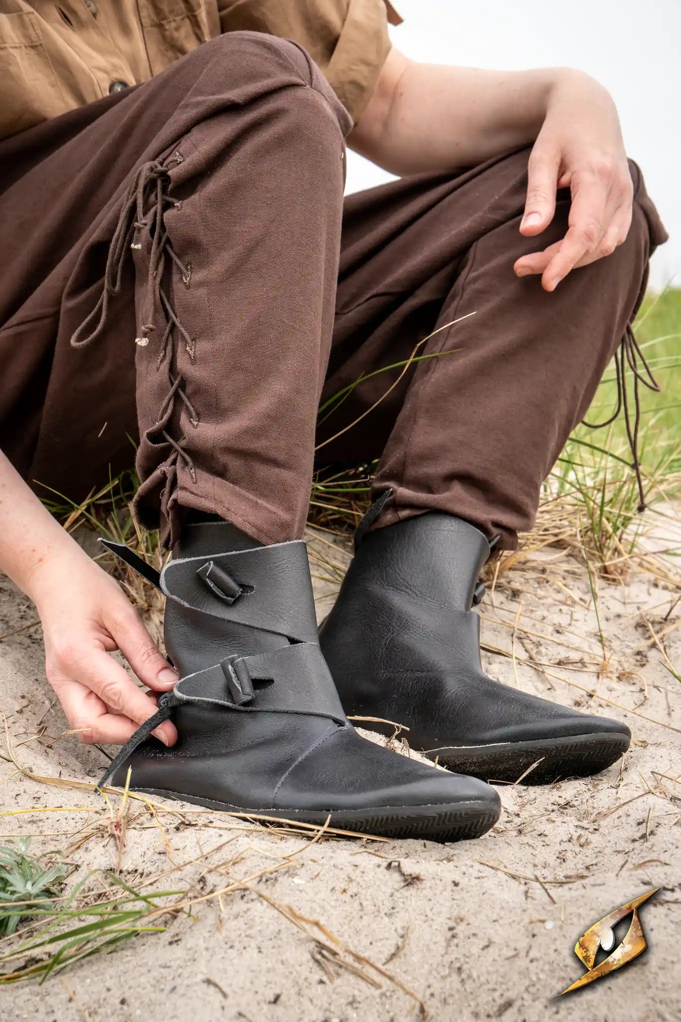 Shoes Jorik worn by a person in a medieval setting, featuring black leather and laces.