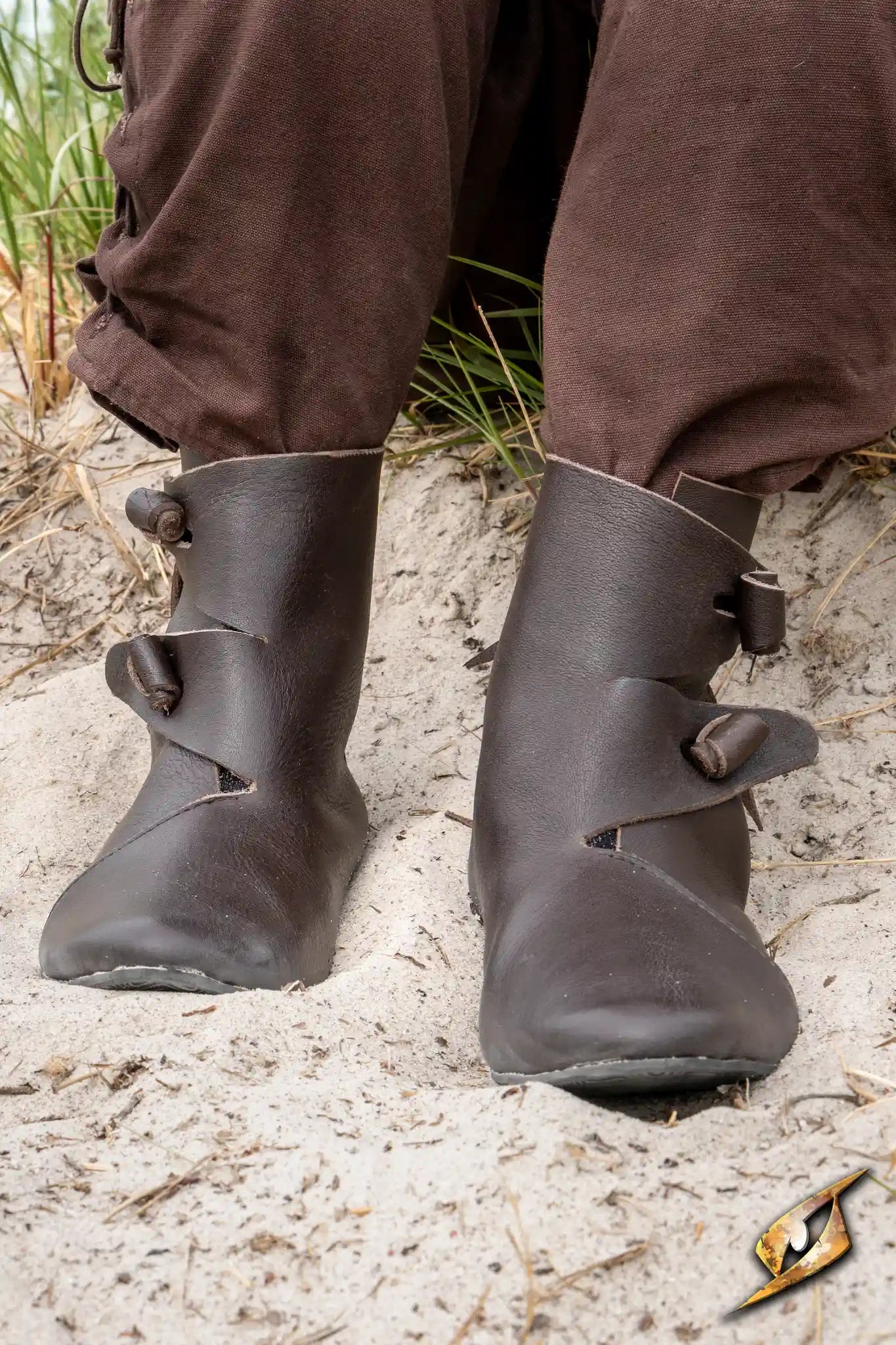 Shoes Jorik displayed on a person's feet in a sandy environment, featuring a medieval design with leather details.
