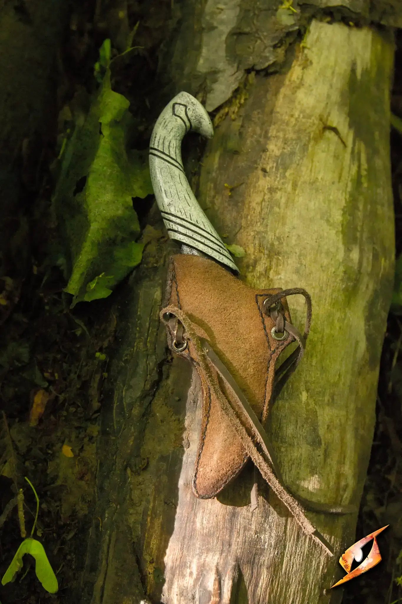 Elven Throwing Knife & Holder displayed on a tree trunk in a woodland setting.