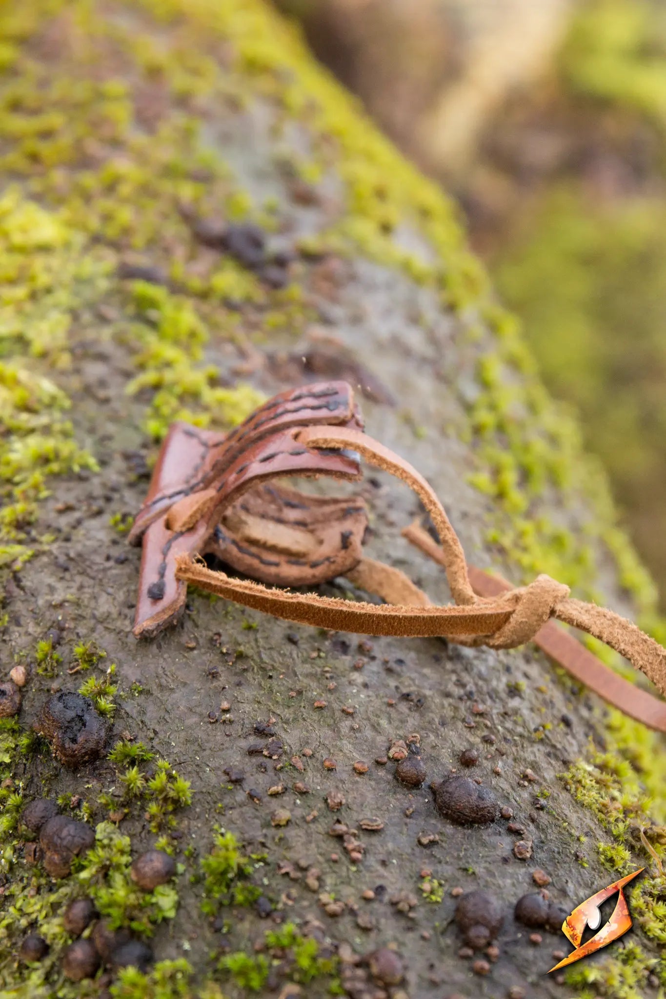 Elven Holster Hook resting on mossy surface in a forest setting, showcasing its detailed design and craftsmanship.