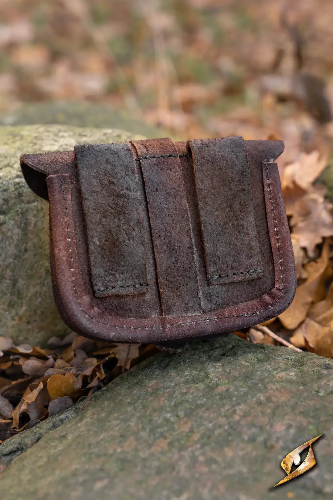Warrior bag - Suede - Small resting on a rock amidst autumn leaves, ideal for storing coins and small items.
