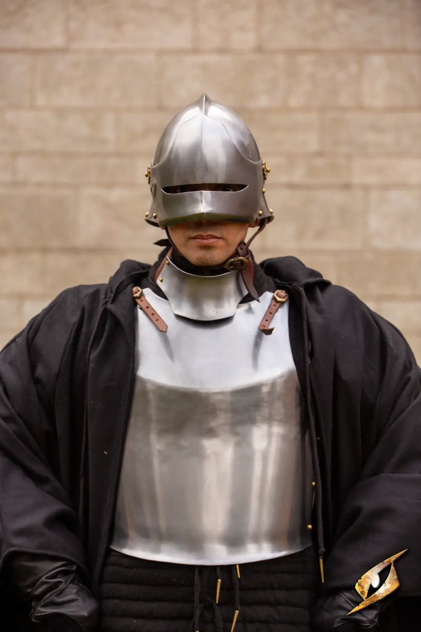 A soldier wearing the Renegade Helmet and armor, standing confidently in front of a stone wall.
