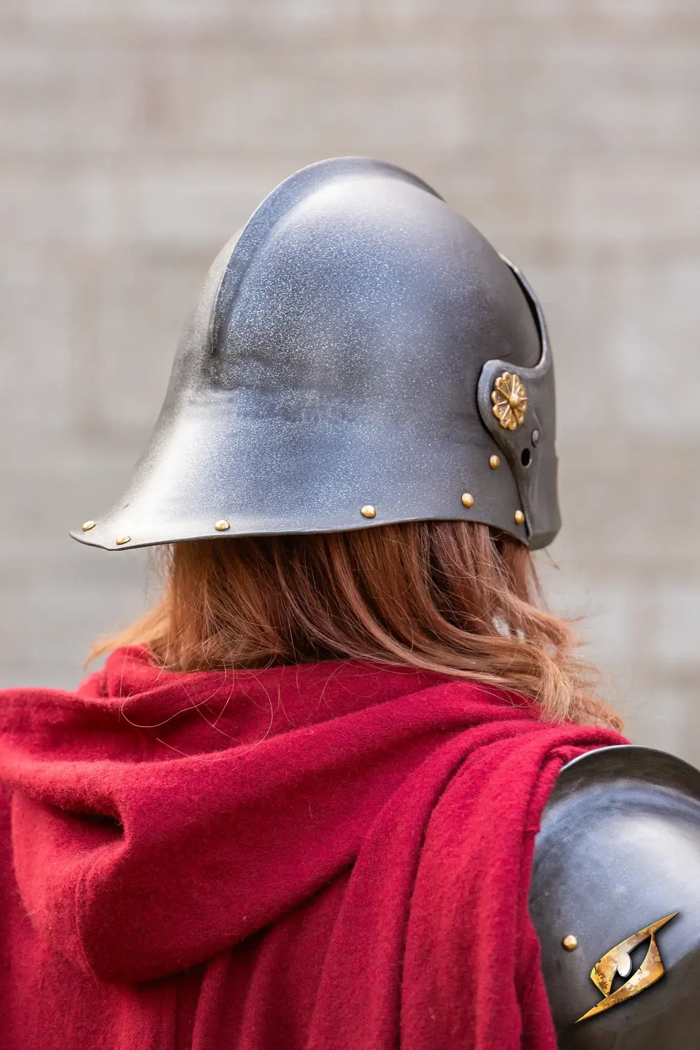 Renegade Helmet worn by a soldier, featuring a dark finish and decorative elements, draped in red fabric.