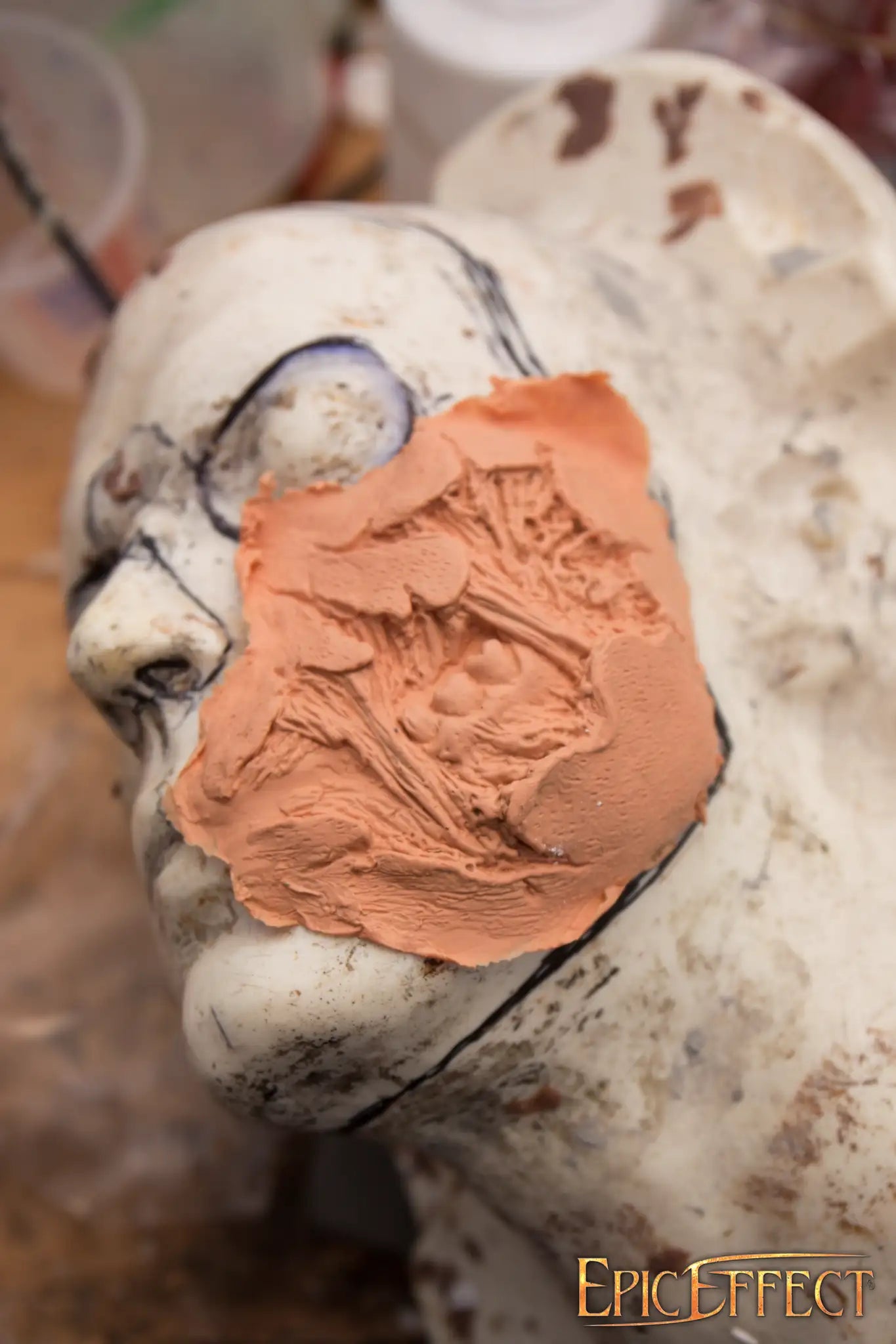 Zombie Cheek Torn makeup process with clay on a sculpture's face at EpicEffect.