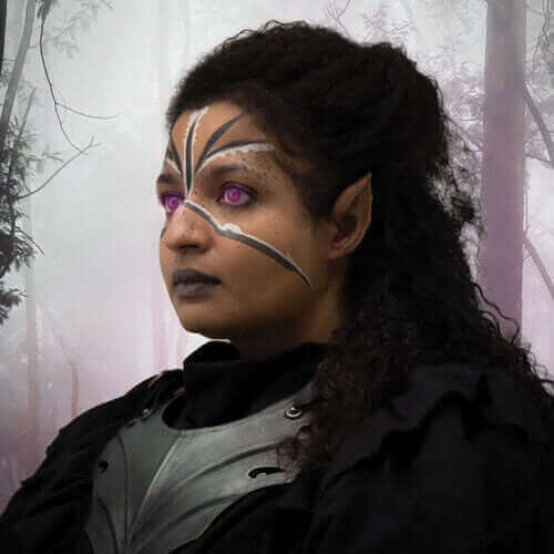 Fantasy character portrait with dark hair, vibrant purple eyes, and intricate face paint in a misty forest.