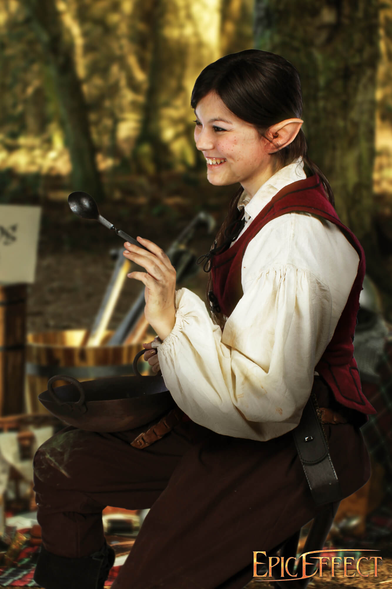 Person with Halfling Ears smiling while holding a spoon, dressed in a fantasy setting.