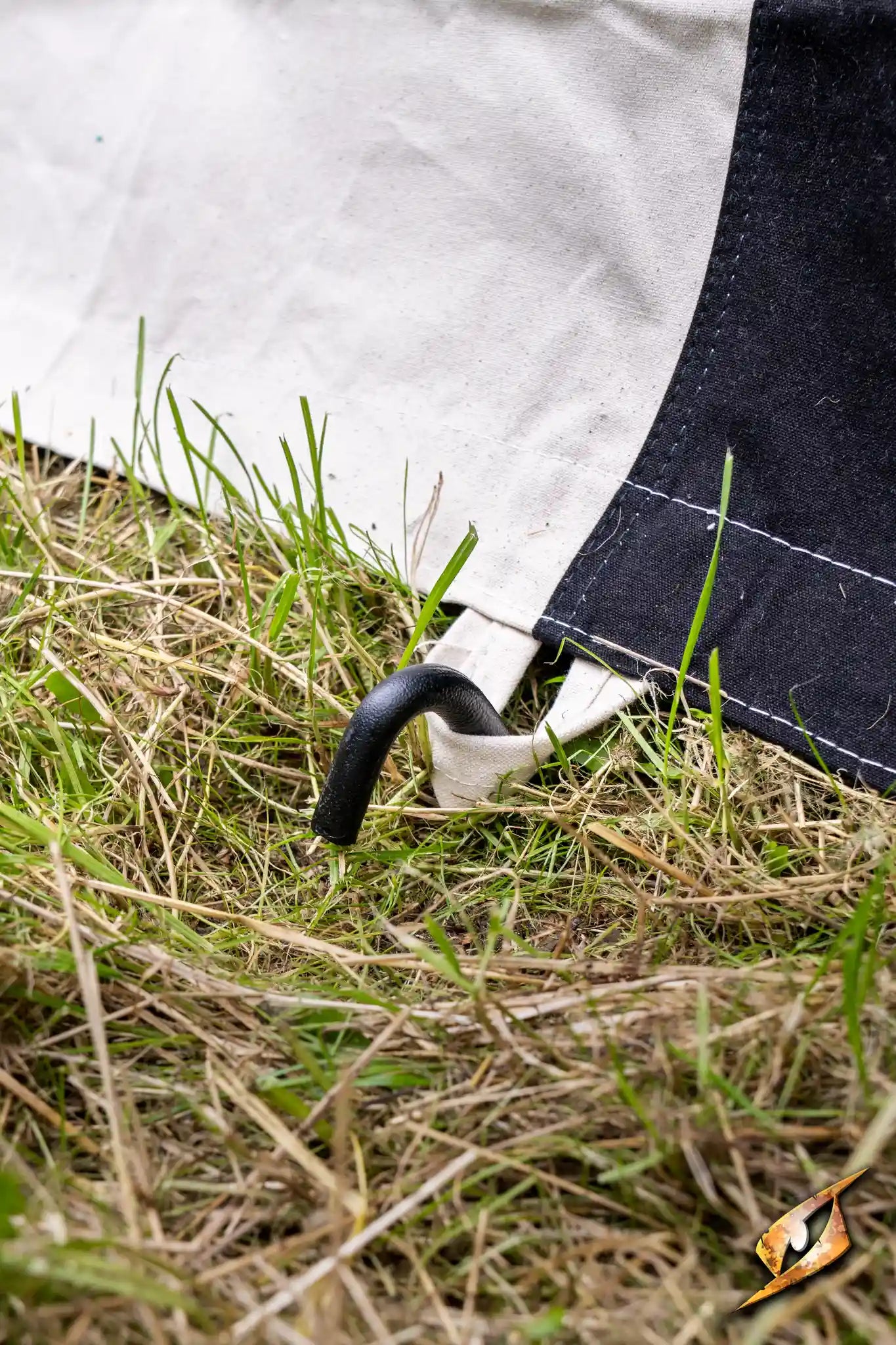 Marquee Tent - 4x4m close-up showing the tent peg securing the fabric to the ground with grass underneath.