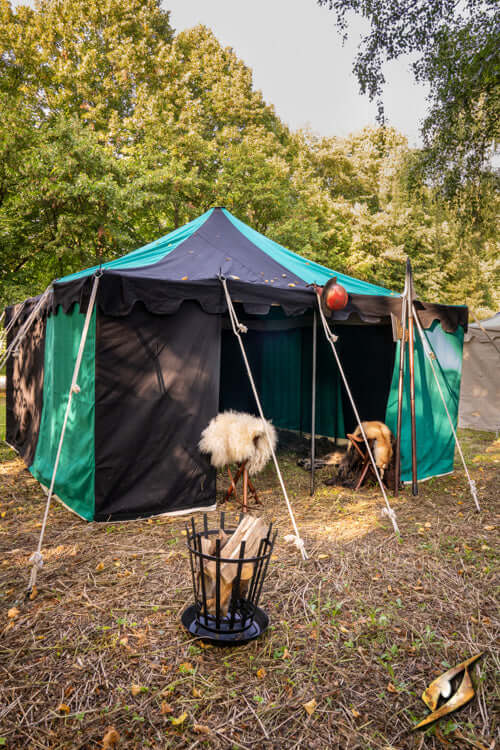 Marquee Tent - 4x4m with green and black fabric, set up outdoors, surrounded by trees and a grassy area.