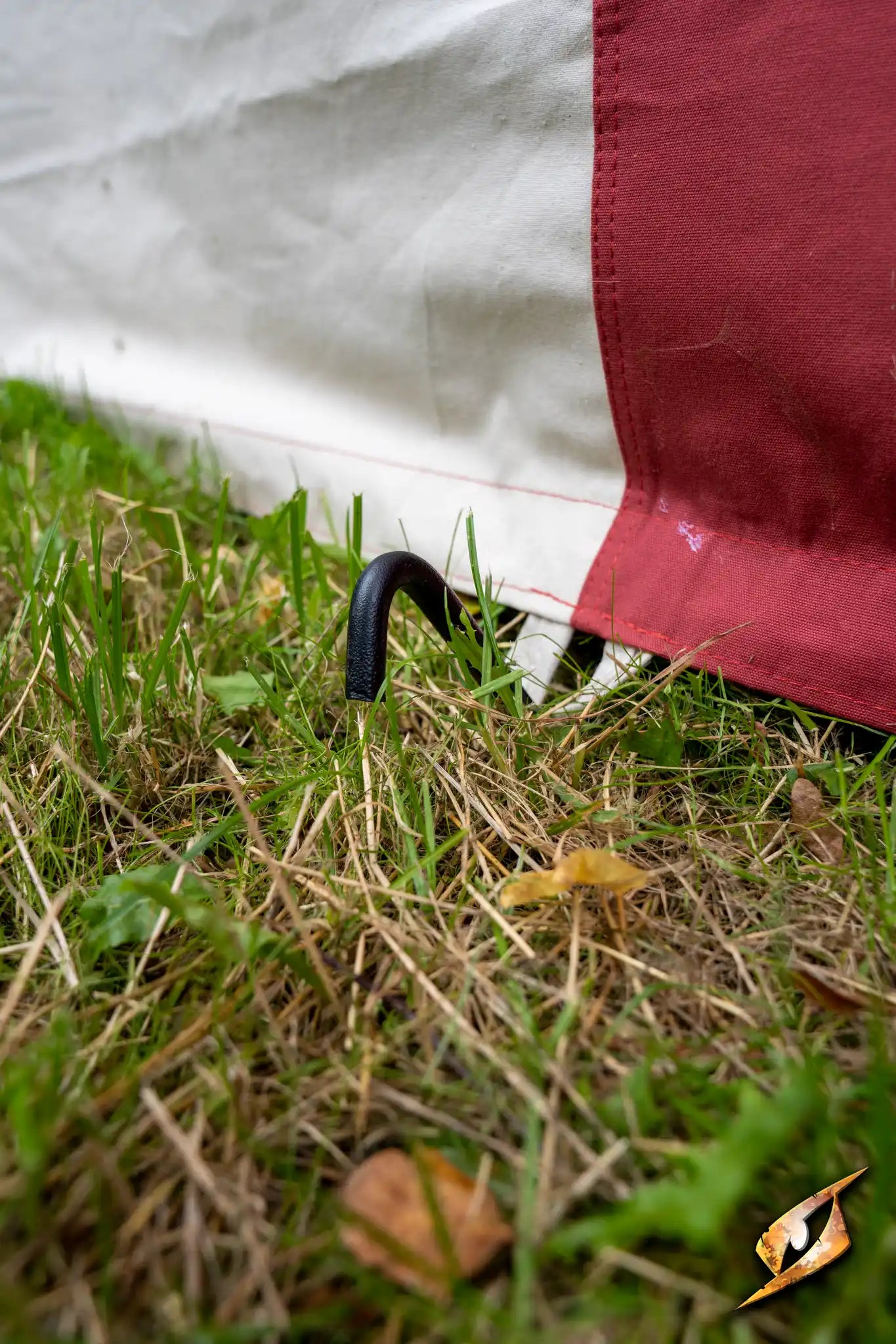 Close-up of the Marquee Tent - 4x6m staking in the grass, showcasing its durable materials and secure setup.