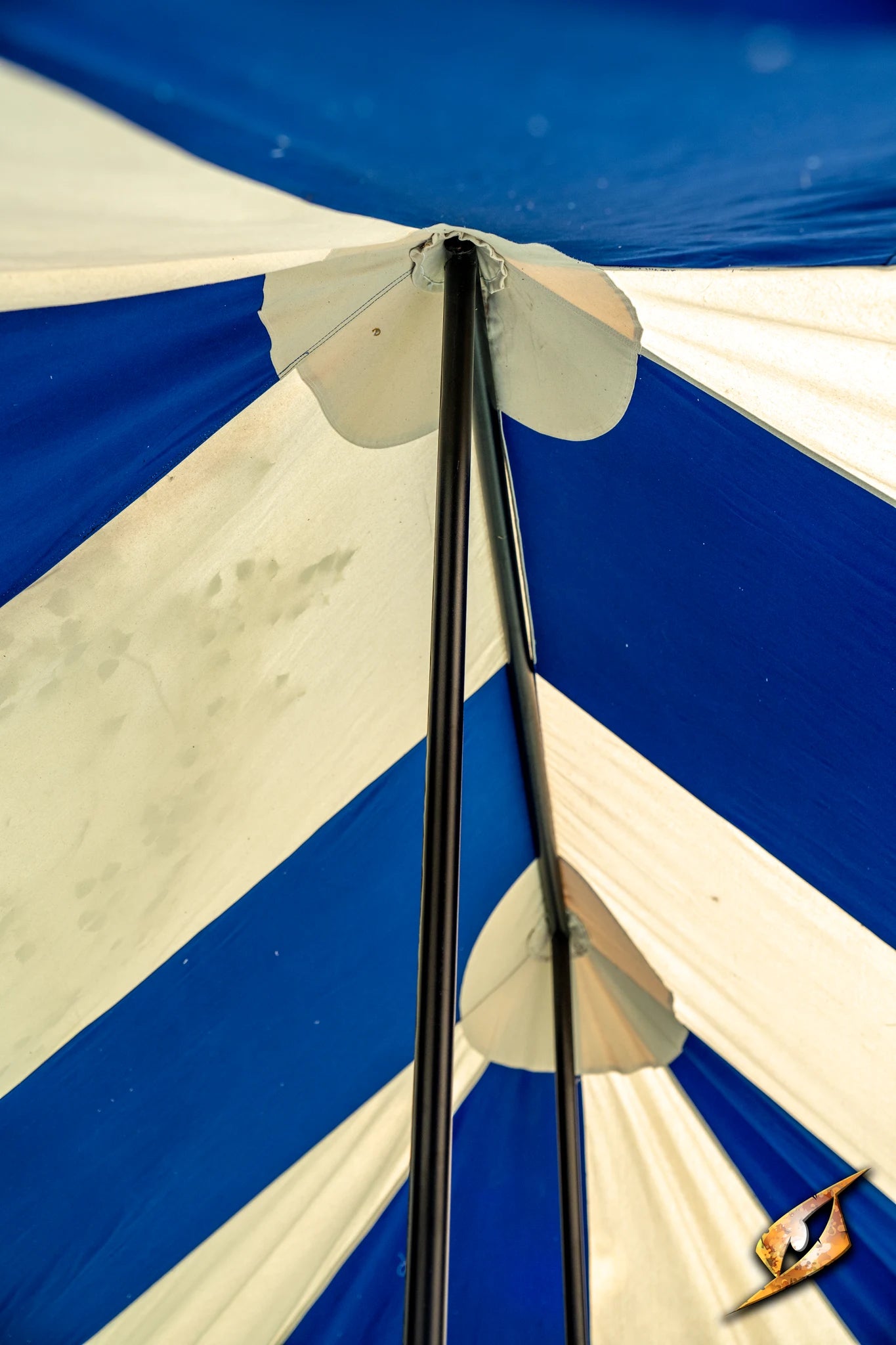 Interior view of a Marquee Tent - 4x6m showcasing its blue and white striped canopy and support poles.