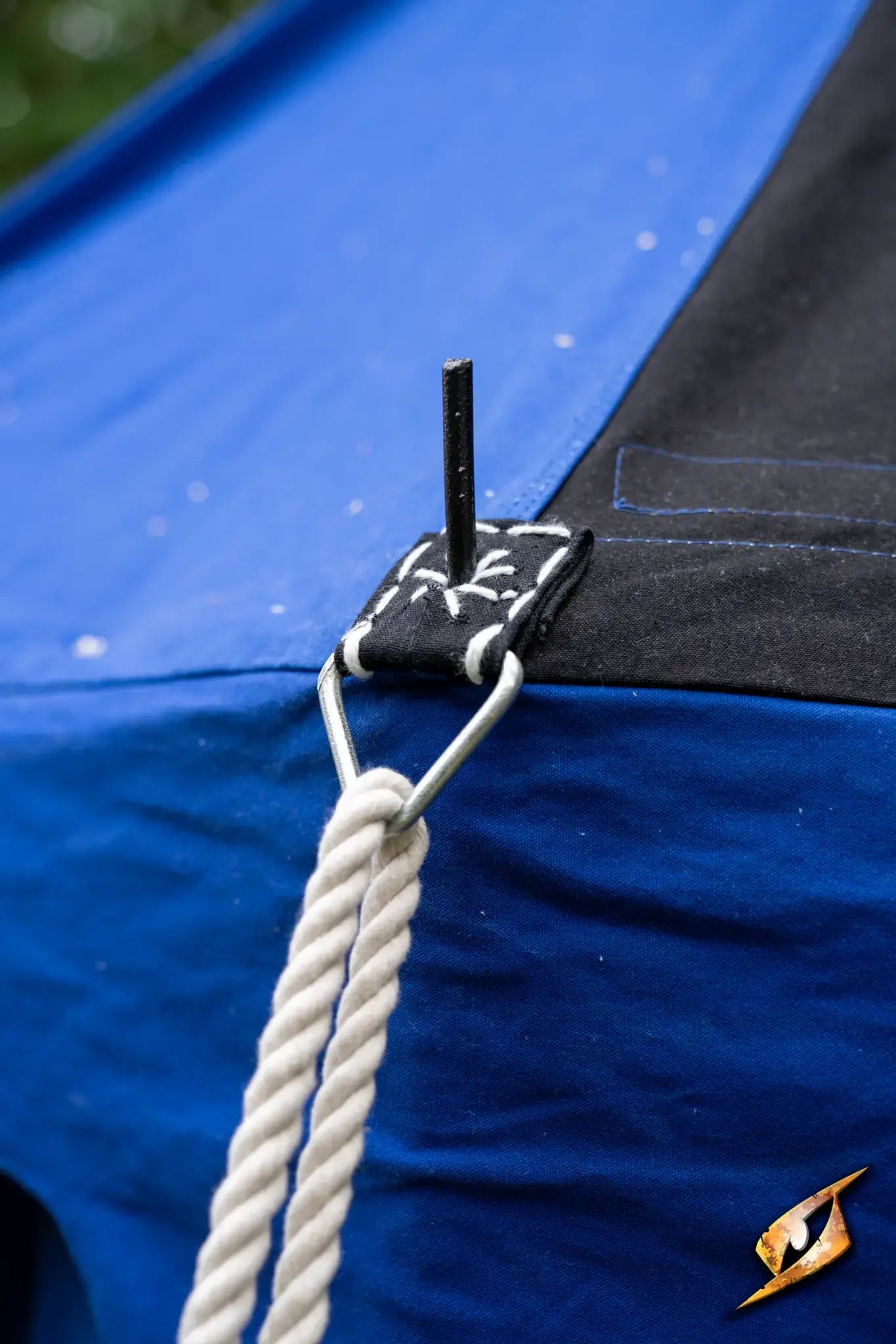 Close-up of the tie-down point on a Marquee Tent - 4x6m showing strap and peg details.