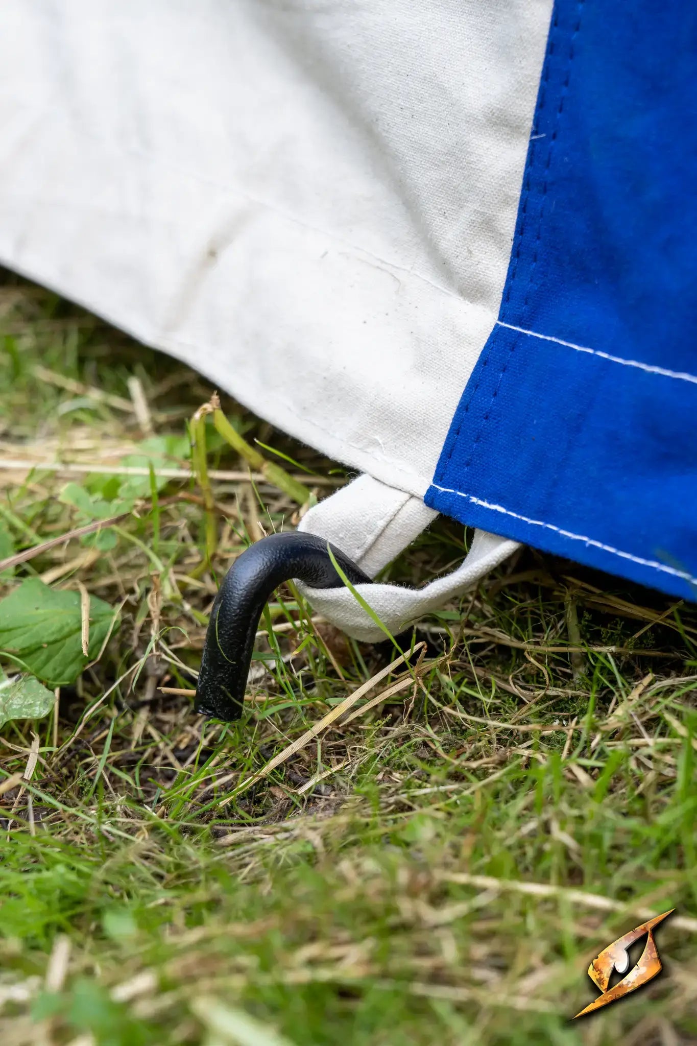 Close-up of a Round Pavilion Tent - 3m stake secured to the ground with grass in the background.