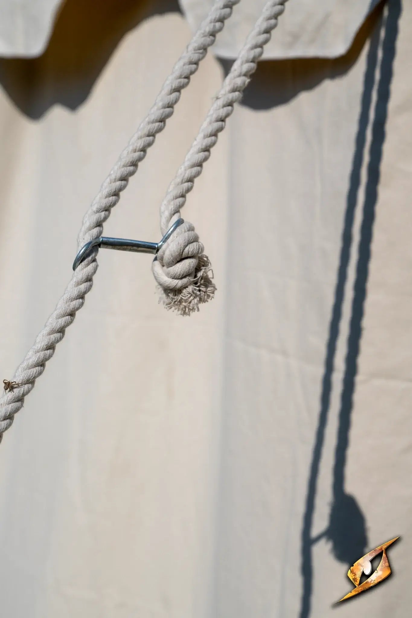 Close-up of a rope knot securing the Round Pavilion Tent - 5 m against a light canvas backdrop.