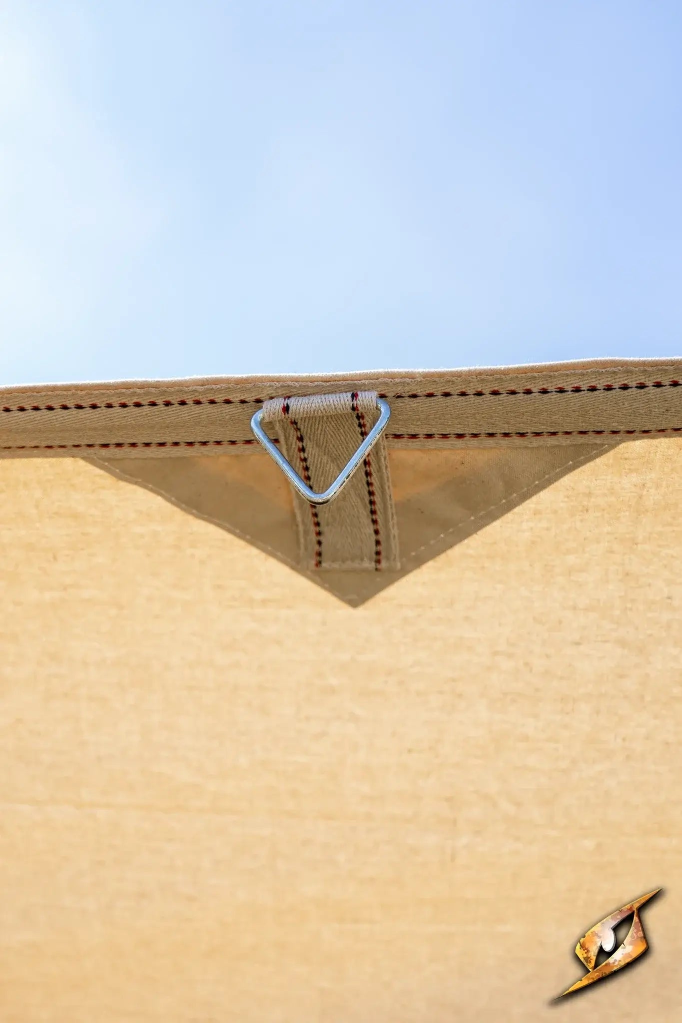 Close-up of the corner patch and triangular ring on the Epic Armoury Tarpaulin for durable securing.