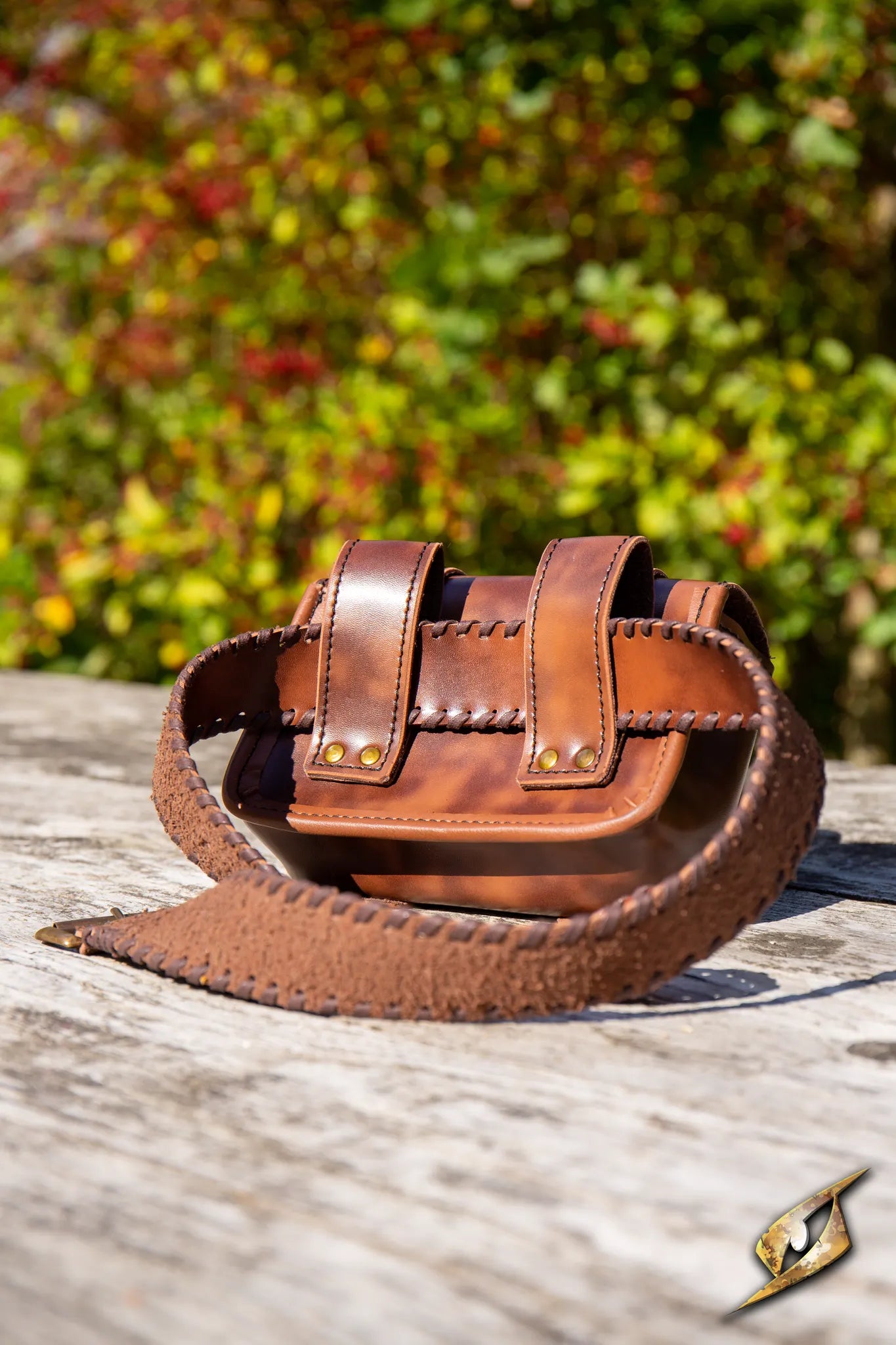 Warrior Bag - Faux Leather - Large resting on a wooden surface with natural background foliage.