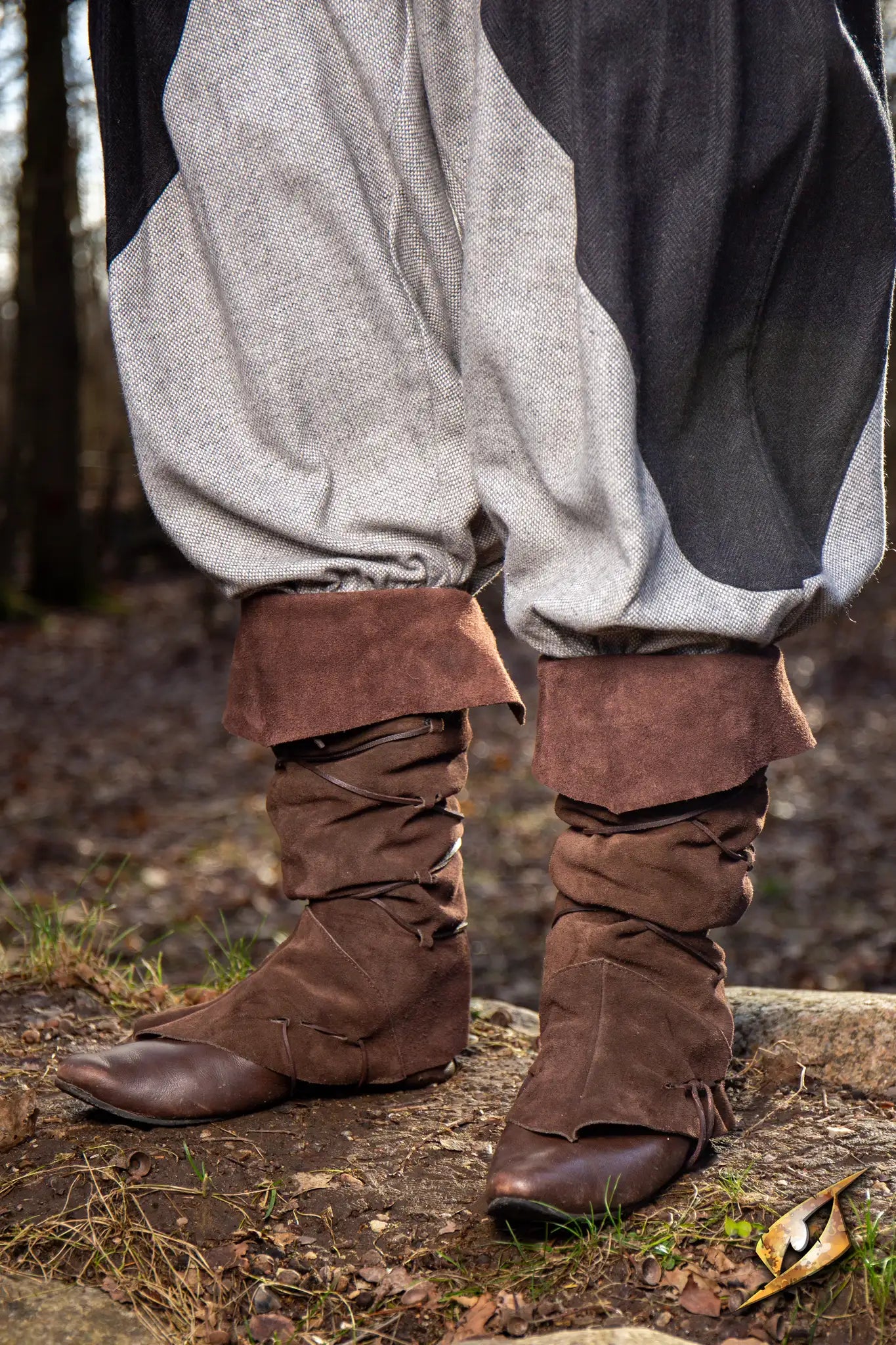Theoderic gaiters styled with brown slouch boots and grey pants on outdoor terrain.