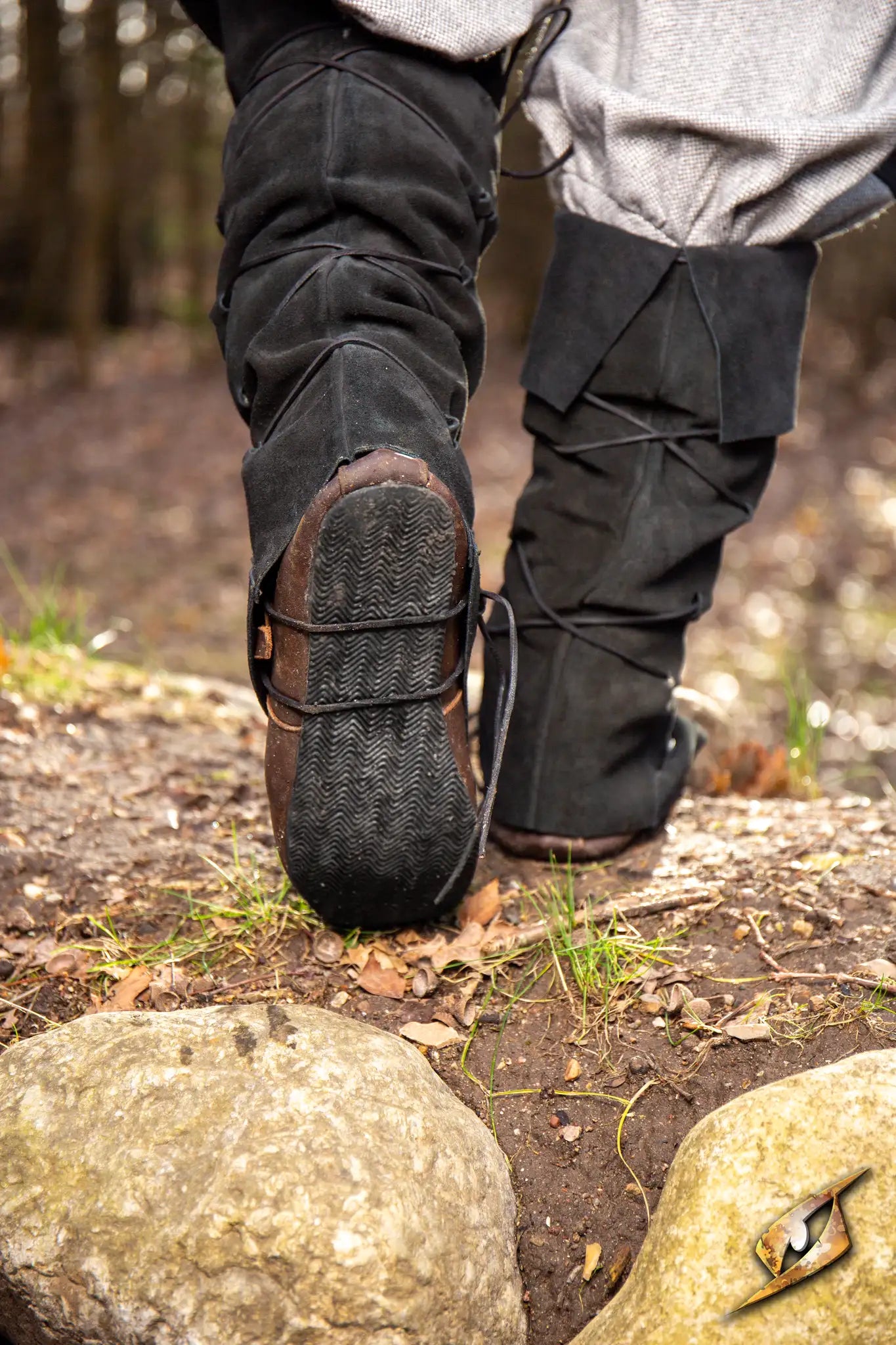 Person walking on a trail wearing Theoderic gaiters, showcasing their durability and stylish design.