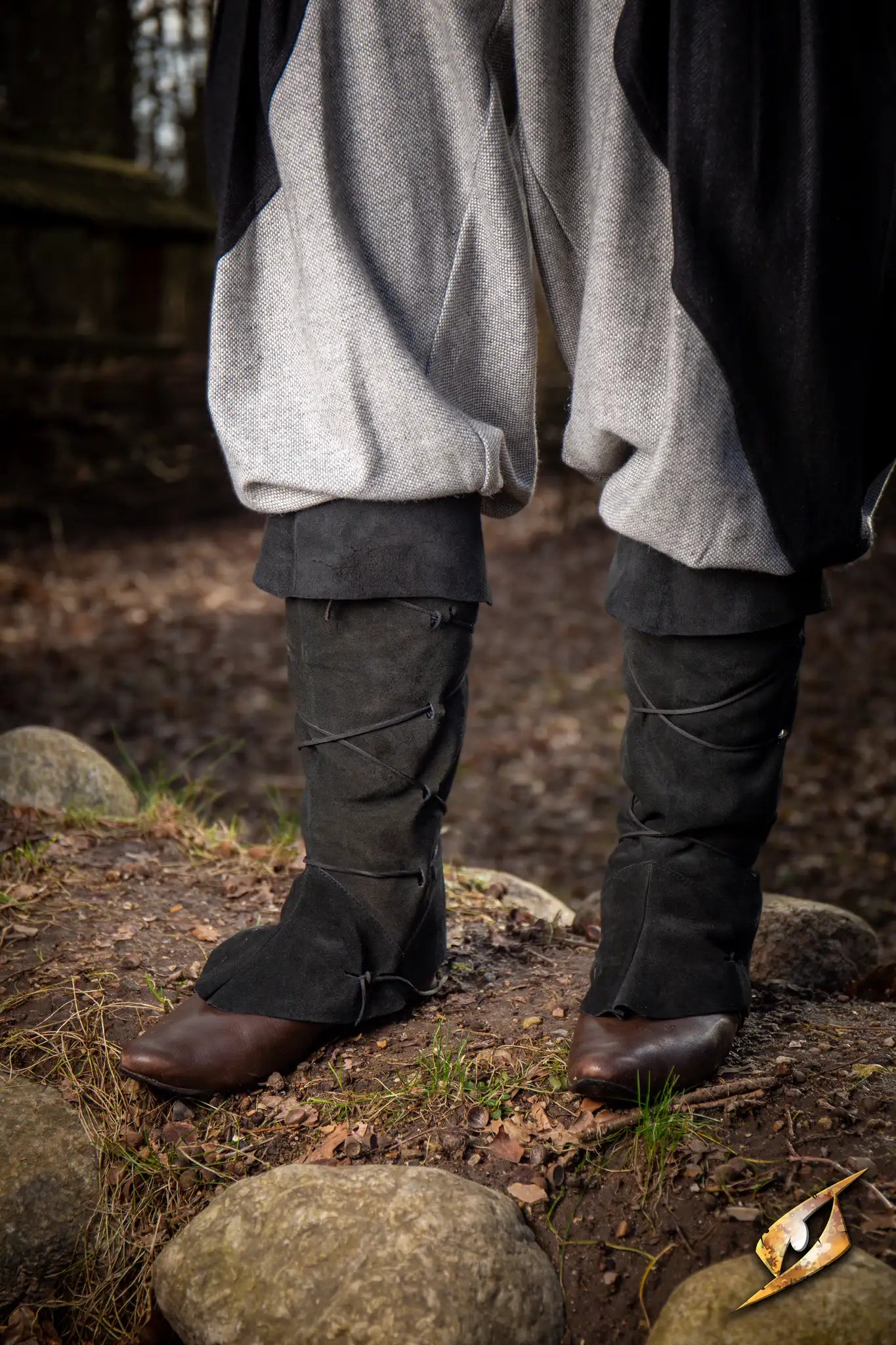 Theoderic gaiters worn with gray pants and brown shoes in a natural outdoor setting.