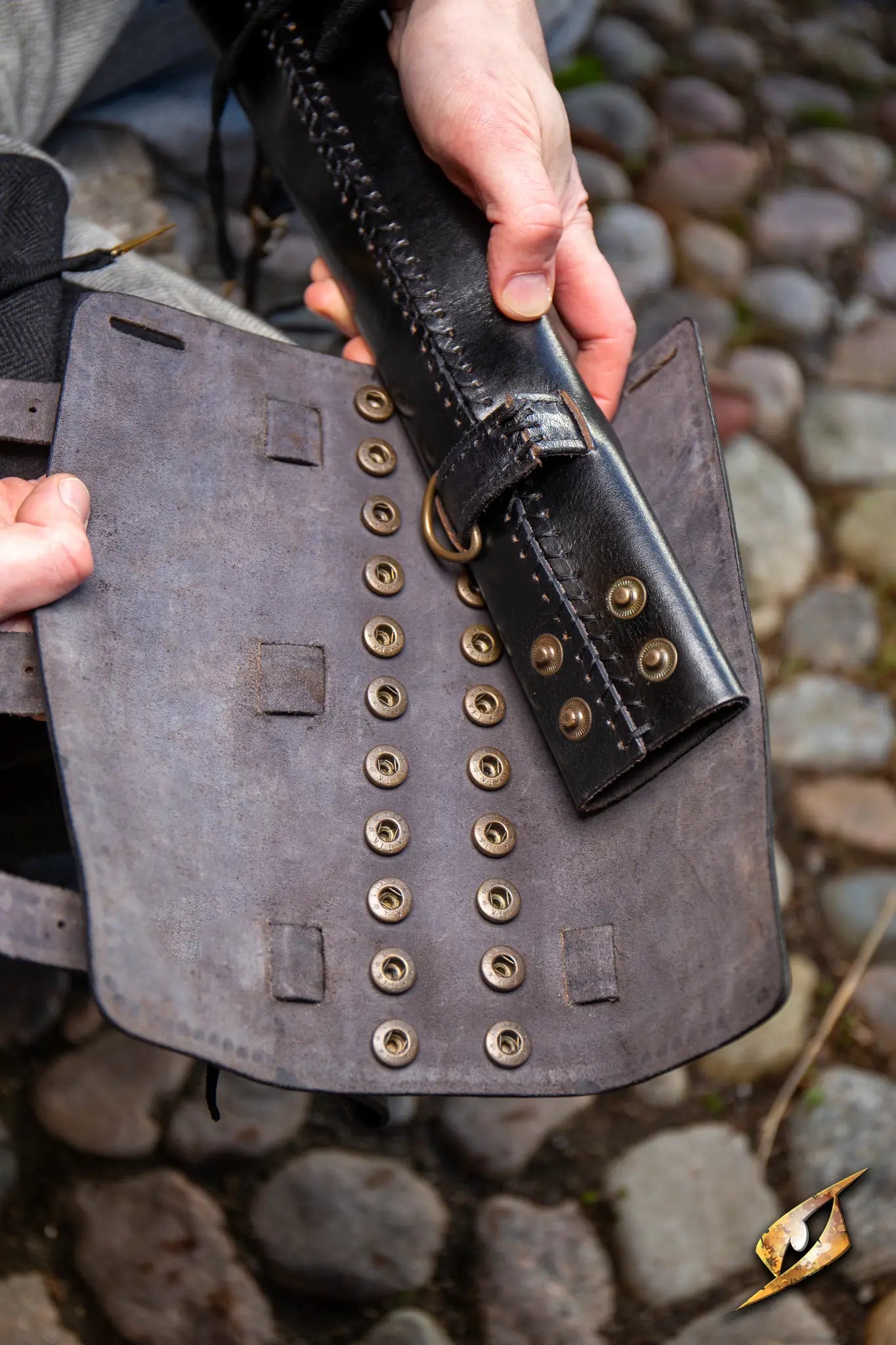 Close-up of hands holding an Adjustable Scabbard showcasing intricate detailing and craftsmanship.
