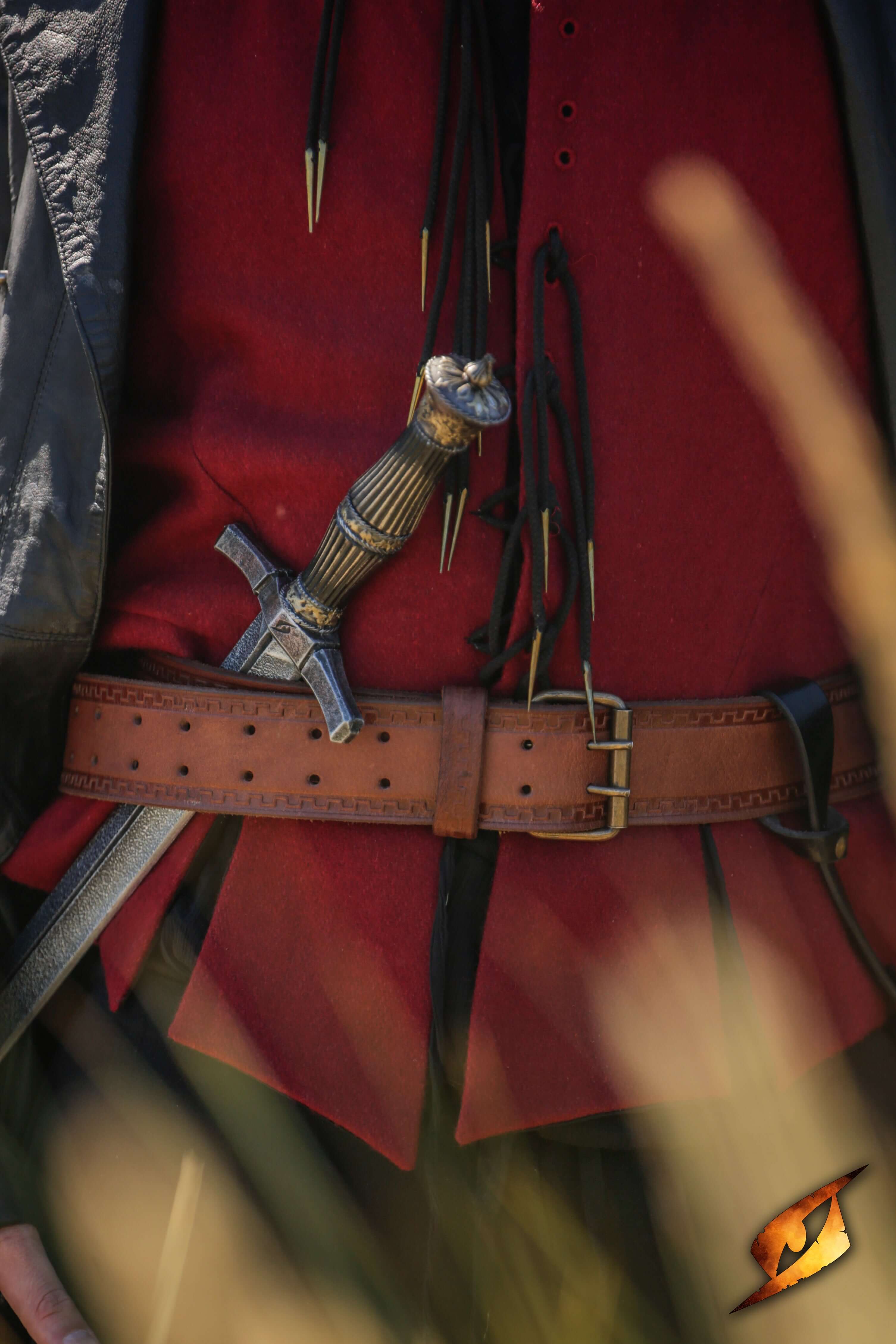 Blocking Dagger worn at the waist, displaying its intricate handle and sharp blade amidst a field background.