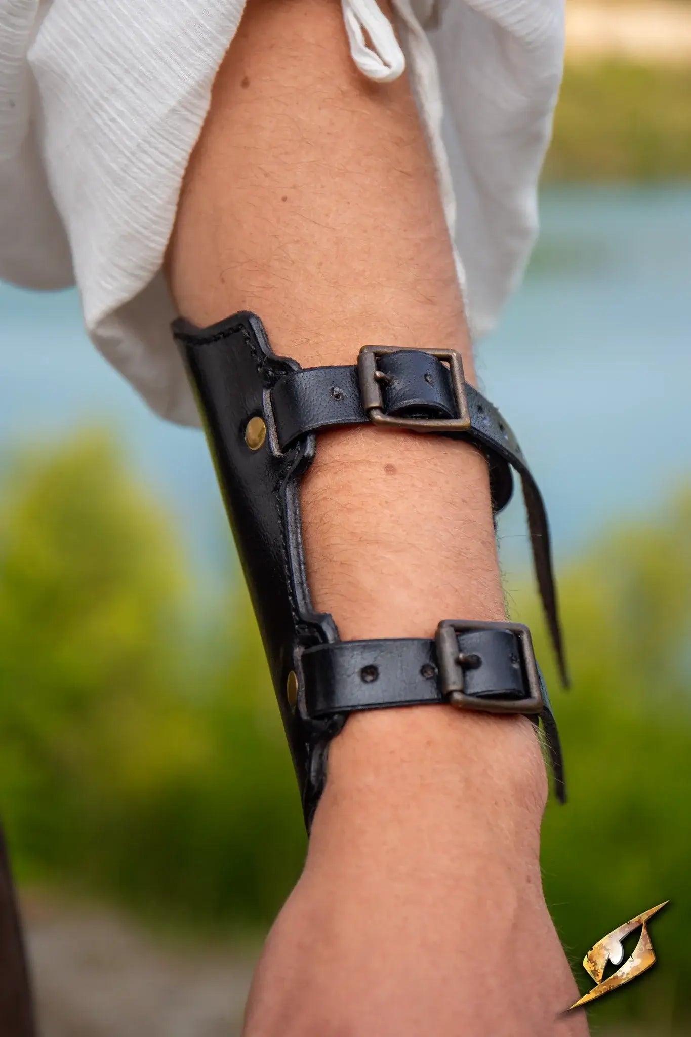 Close-up of a leather Archery Bracer worn on an arm, featuring buckles and a stylish design for archers.