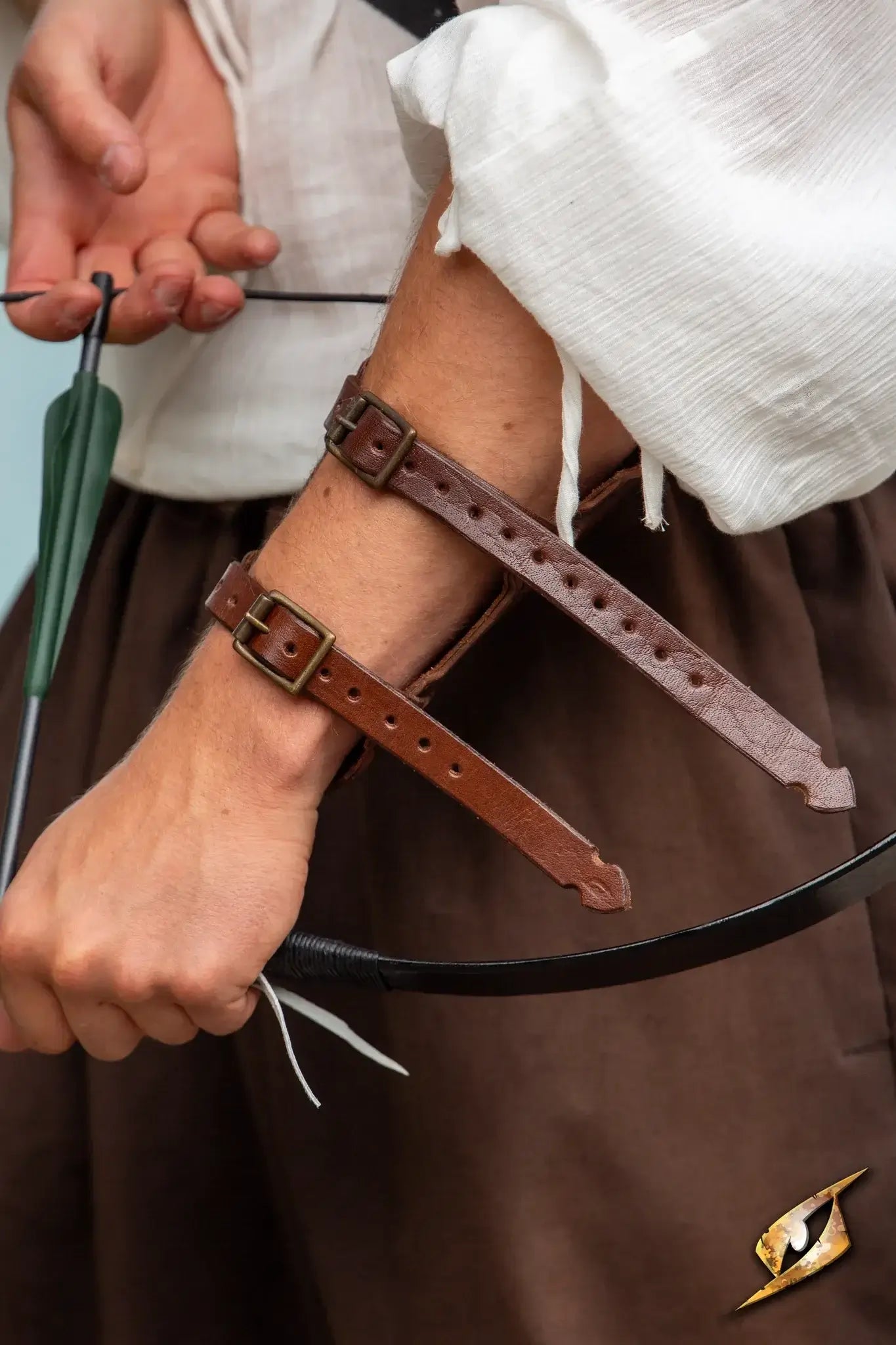 Person wearing an Archery Bracer on their arm, preparing to shoot an arrow with a bow.