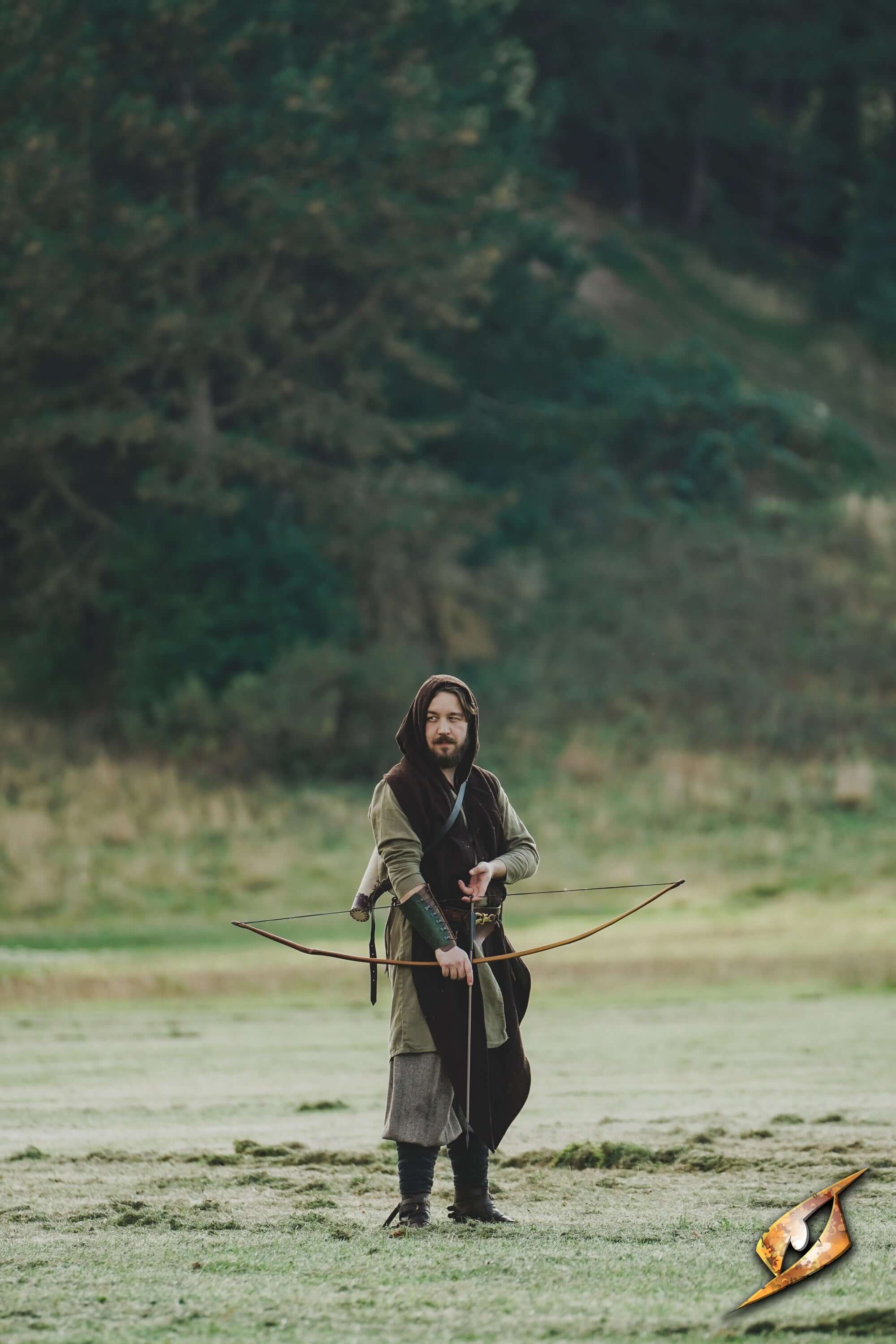 Archer wearing Glade Warden Bracer in a forest setting, showcasing comfort and style for archery enthusiasts.