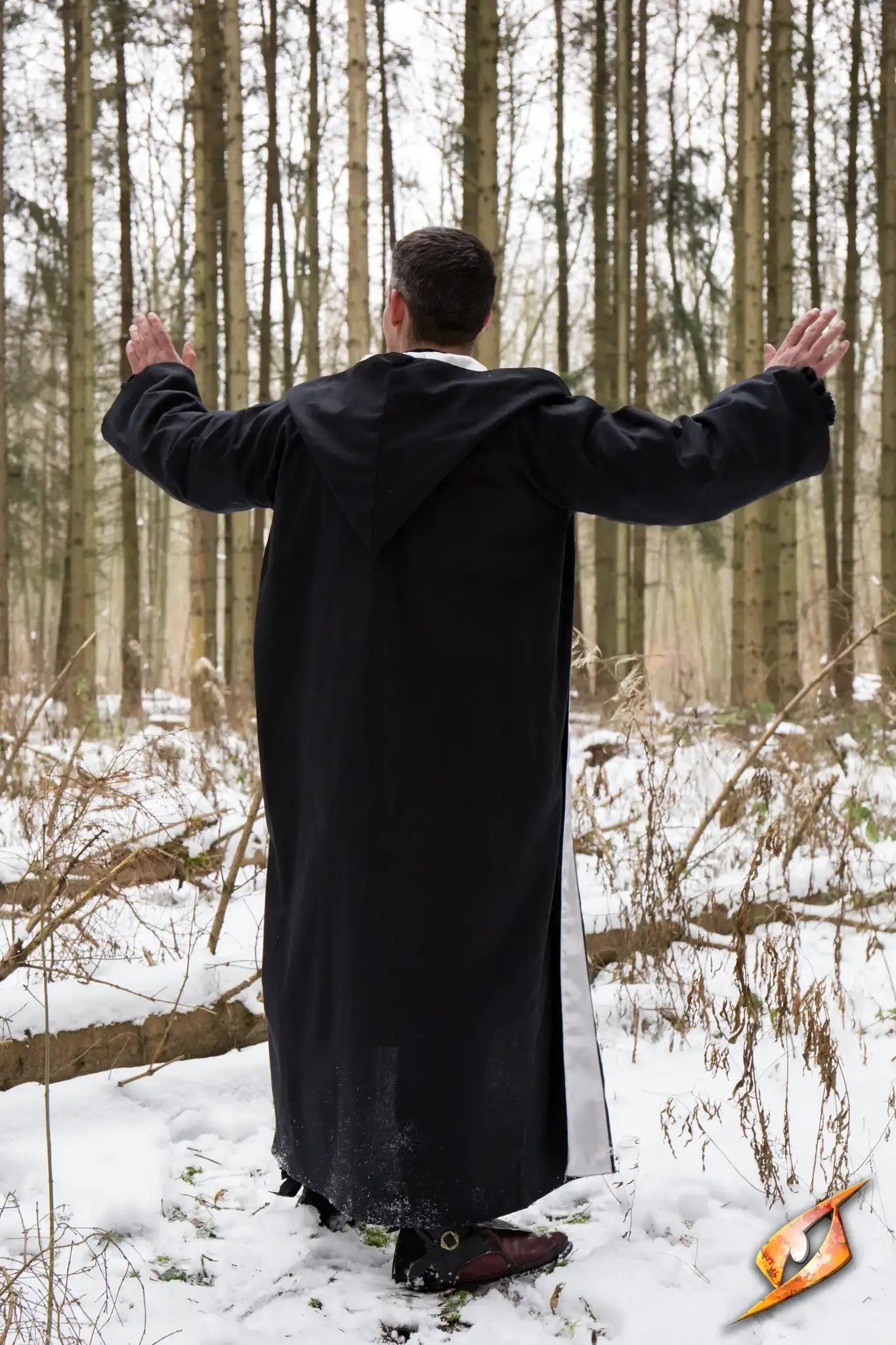 Magician Robe worn by a man in a snowy forest, arms raised as if casting a spell.