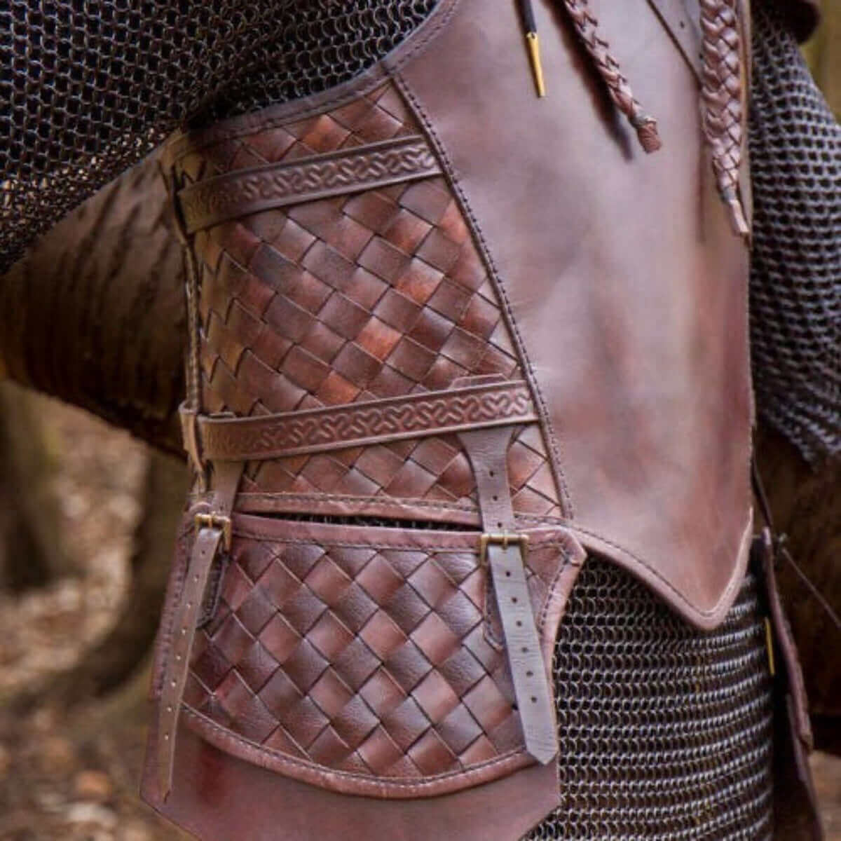 Close-up of a medieval brown leather chestplate with intricate woven patterns, showcasing detailed craftsmanship.
