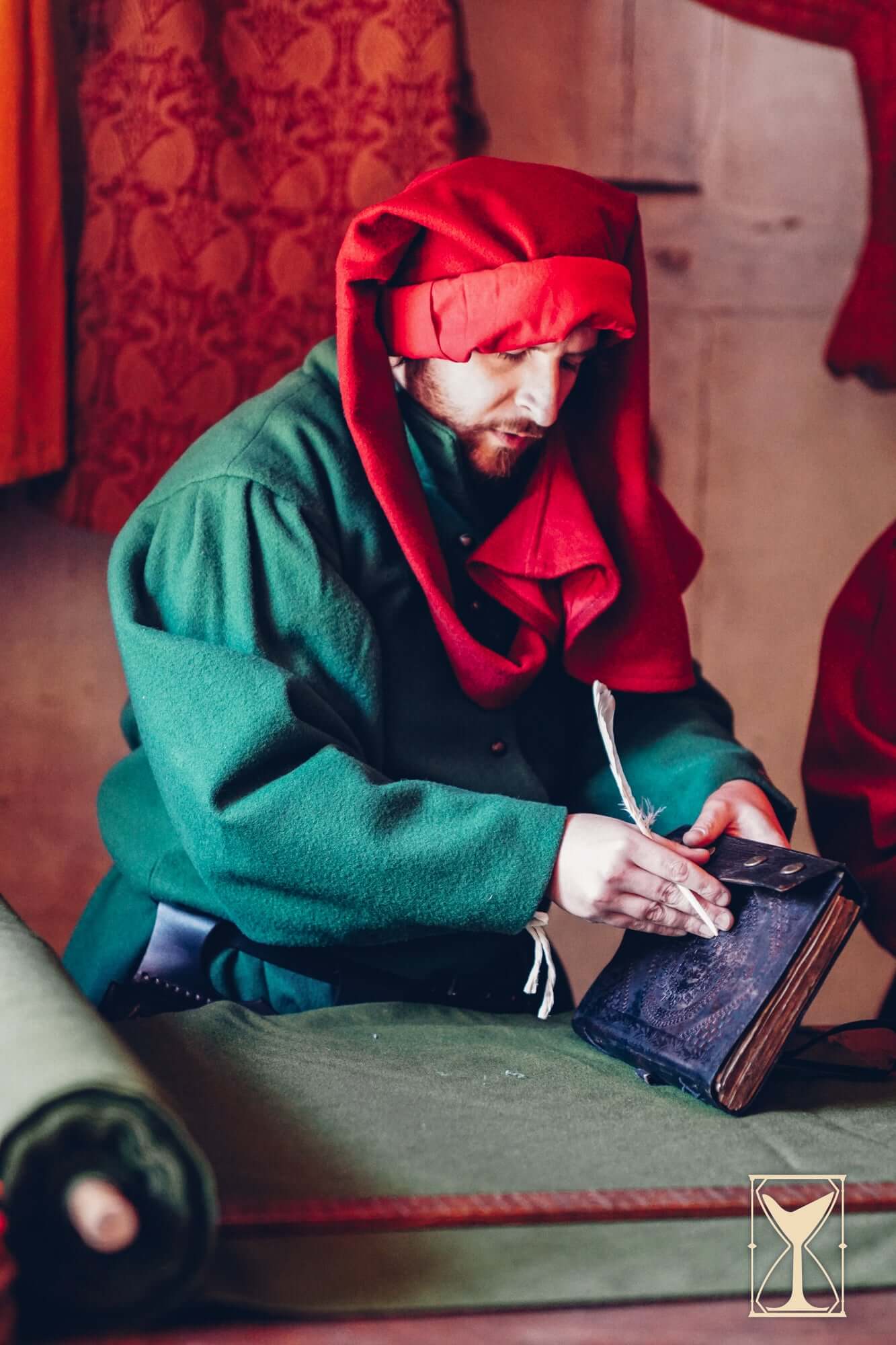 Simple Liripipe Hood - Brushed Wool worn by a man in medieval clothing while writing in a book.