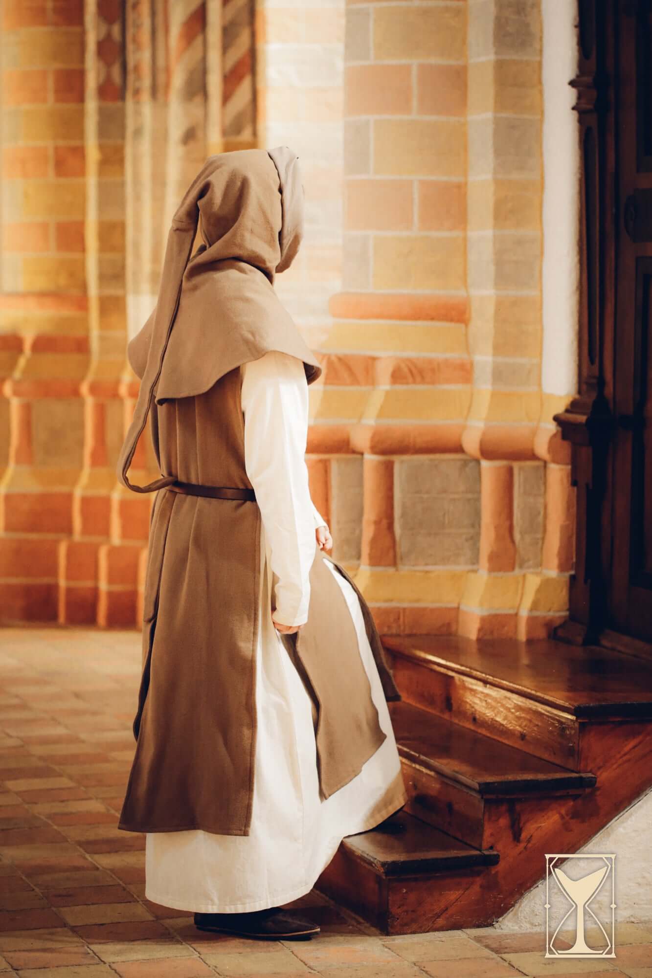 Simple Liripipe Hood - Brushed Wool worn by a person ascending steps in a medieval setting.