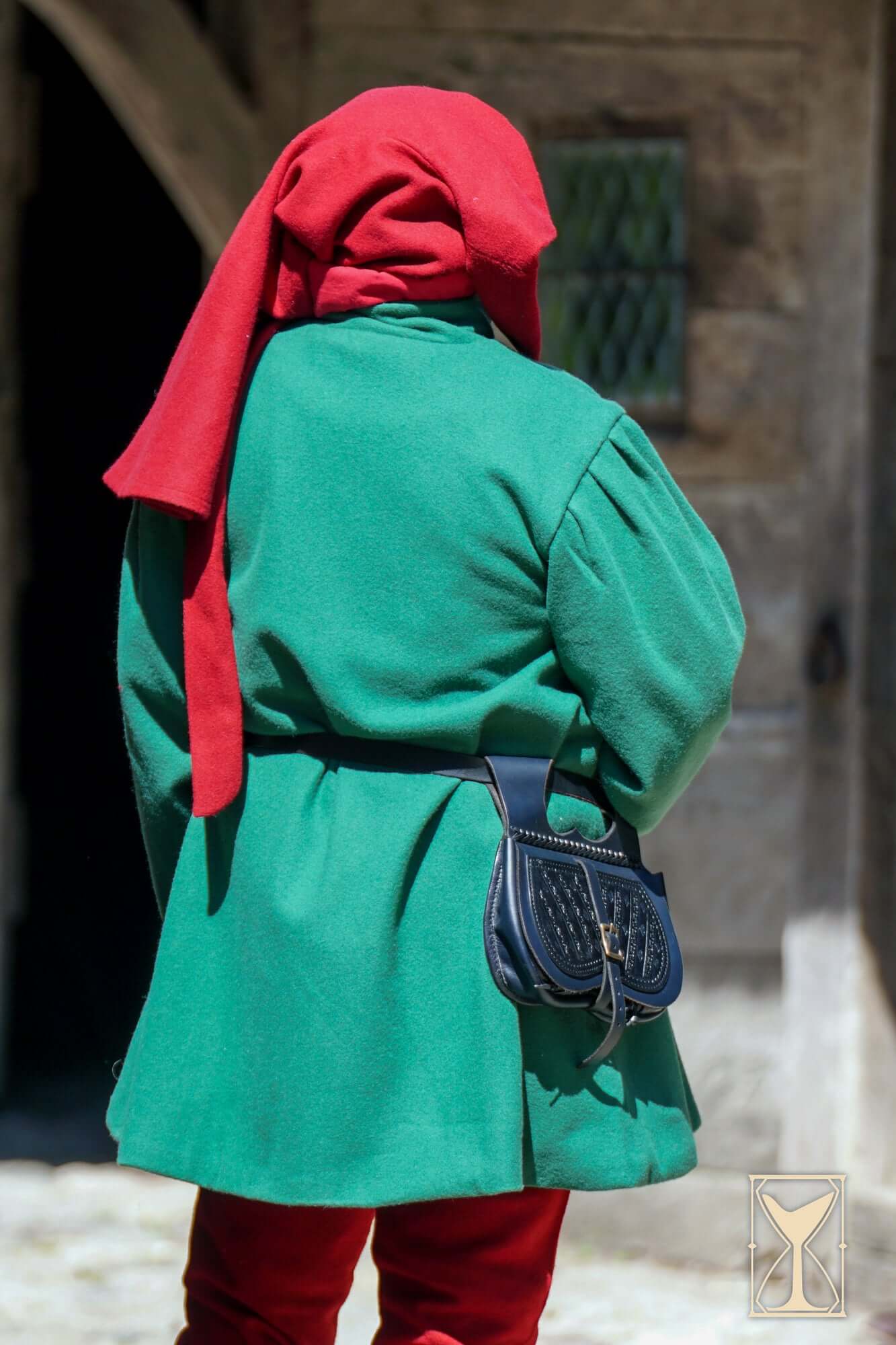 Surcoat Lorenzo worn by a person, featuring a green coat and red head wrap, showcasing 14th to 15th-century style.
