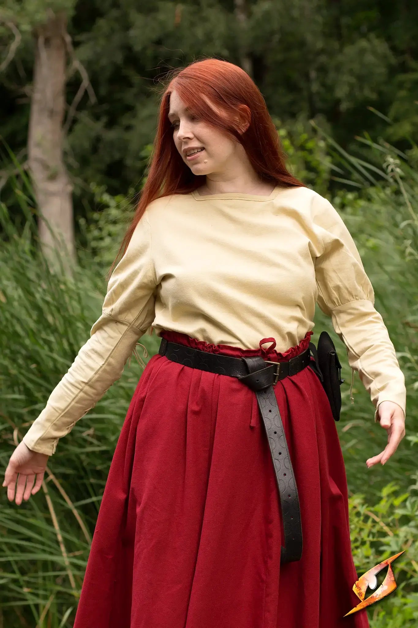 Empire Shirt worn with a red skirt, featuring puffy shoulders and a trimmed square neckline in a natural setting.