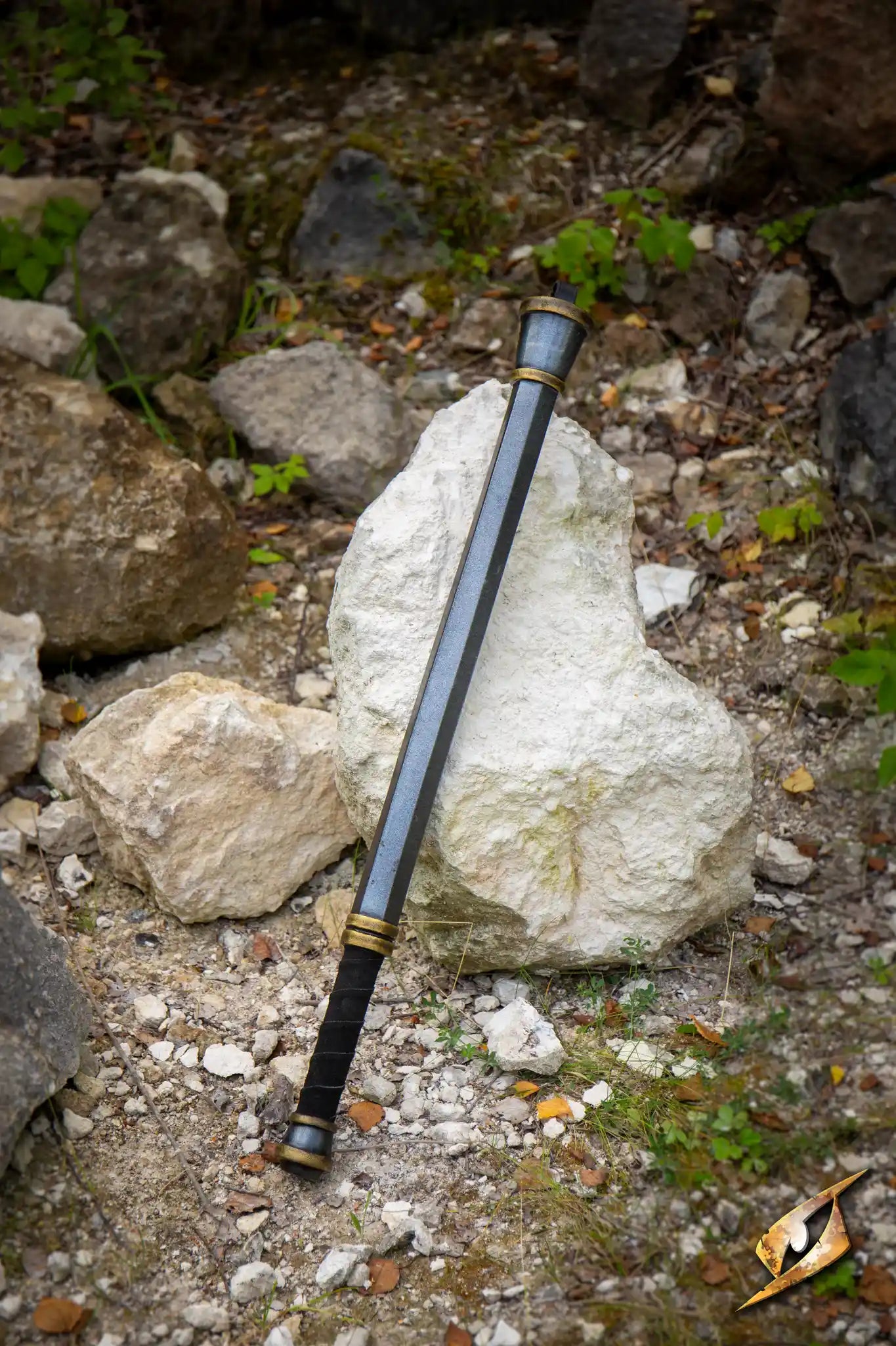 Steelstorm Flail Handle resting on a rock in a natural setting, showcasing its sturdy design and craftsmanship.