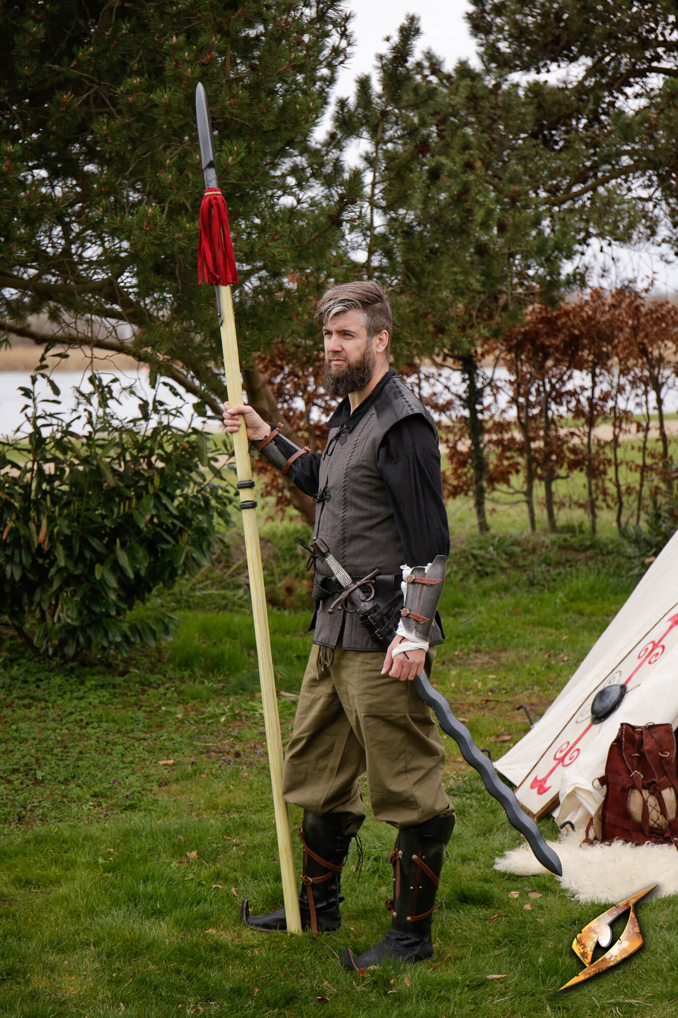 Landsknecht Pike held by a man in historical attire standing outdoors with greenery in the background.