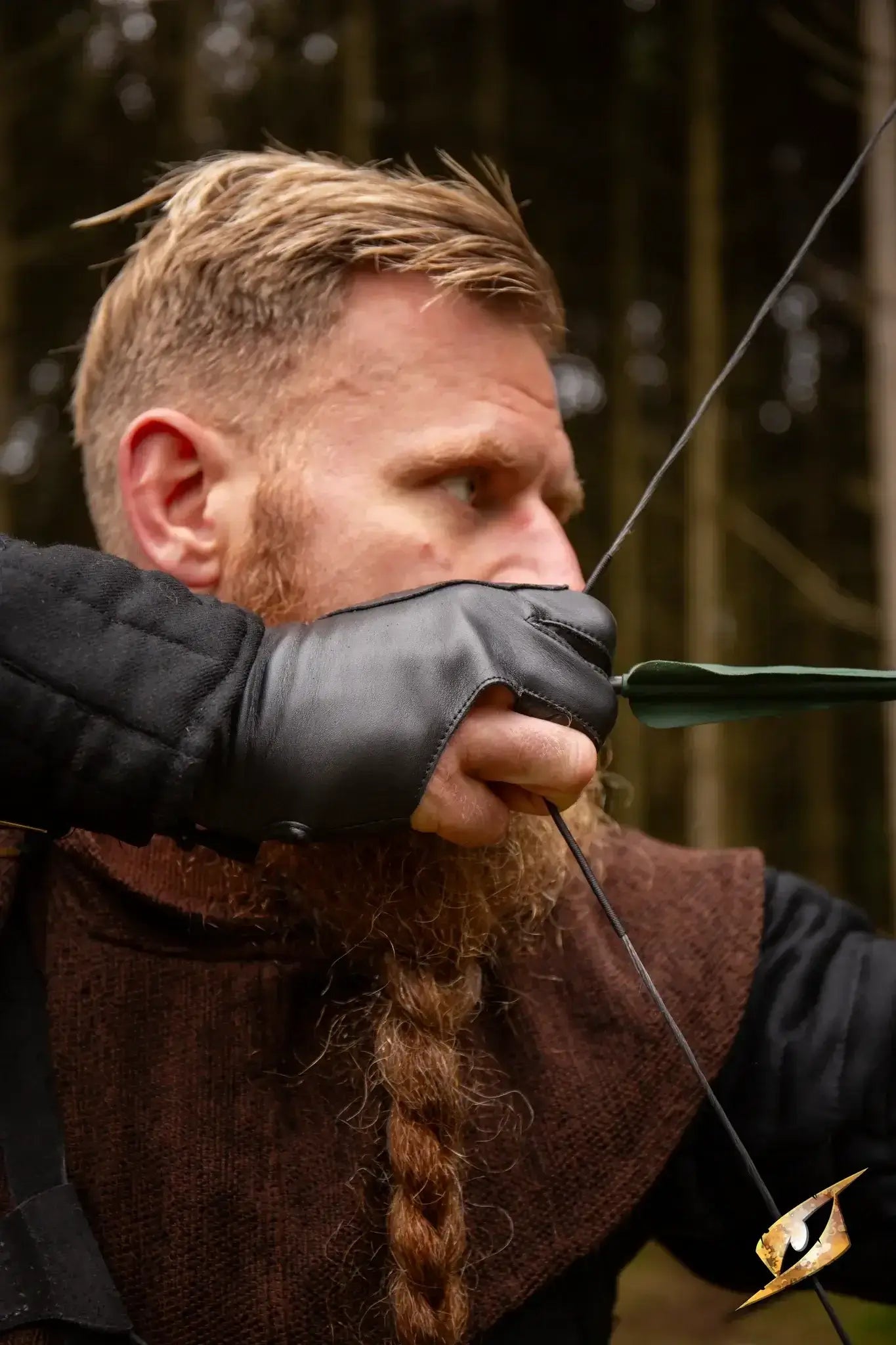 Archer using an Archery Half-glove while aiming with a bow in a natural setting.