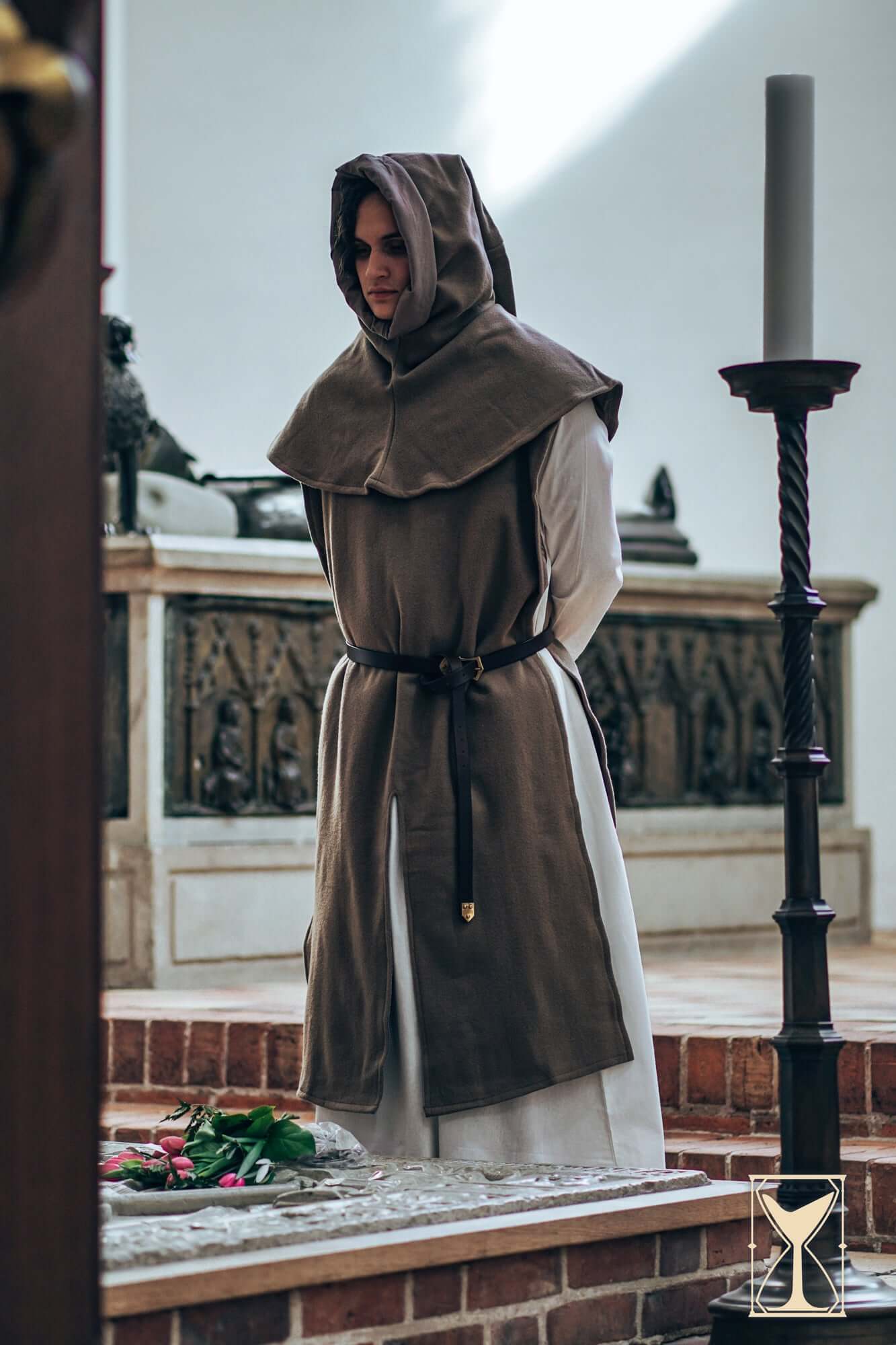 Model wearing a Cyclas Bernard layered over-tunic with hood, embodying medieval fashion and realism.