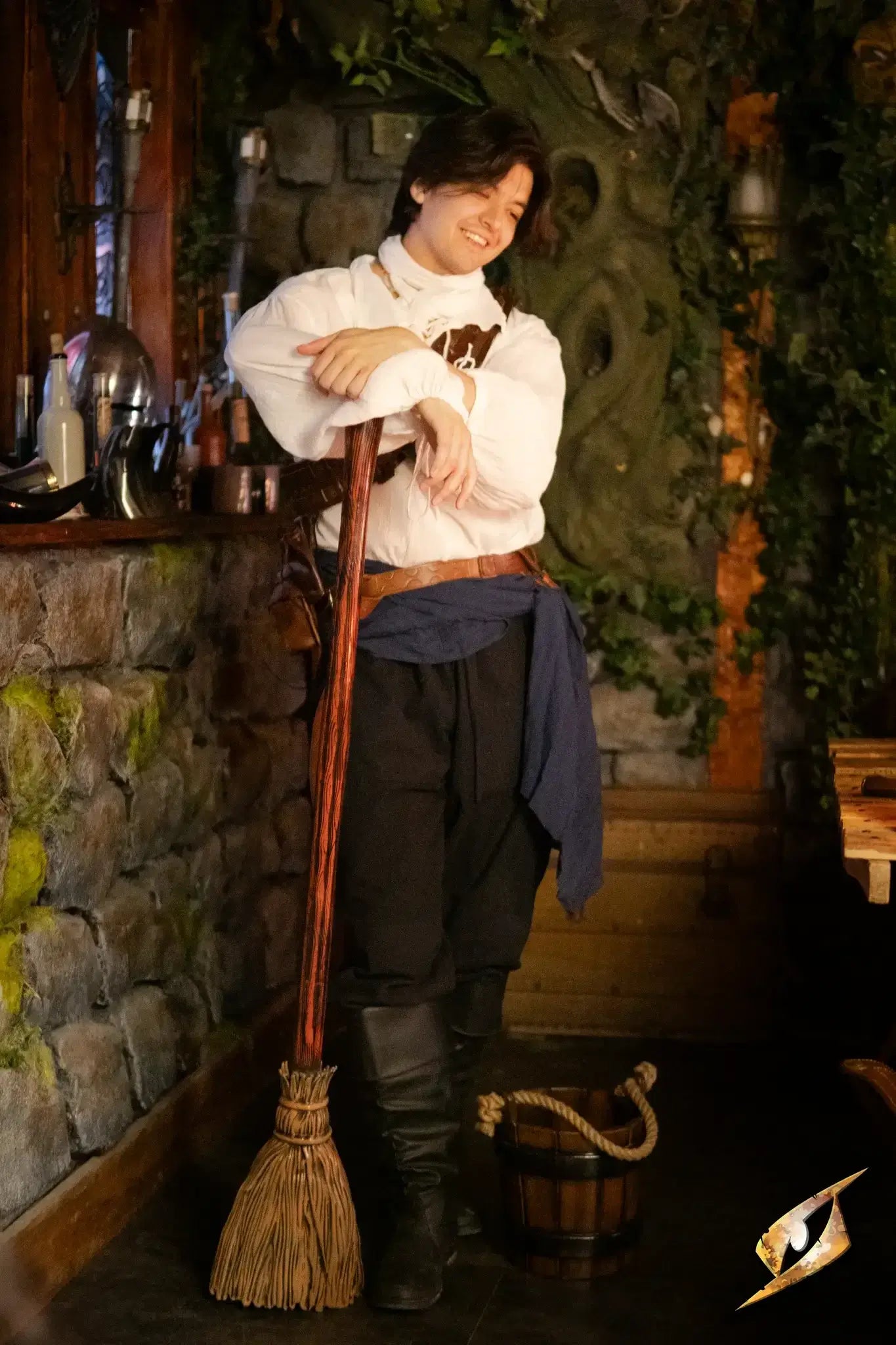 Broomstick leaning against a character in a rustic tavern setting, ready for cleaning or adventure.